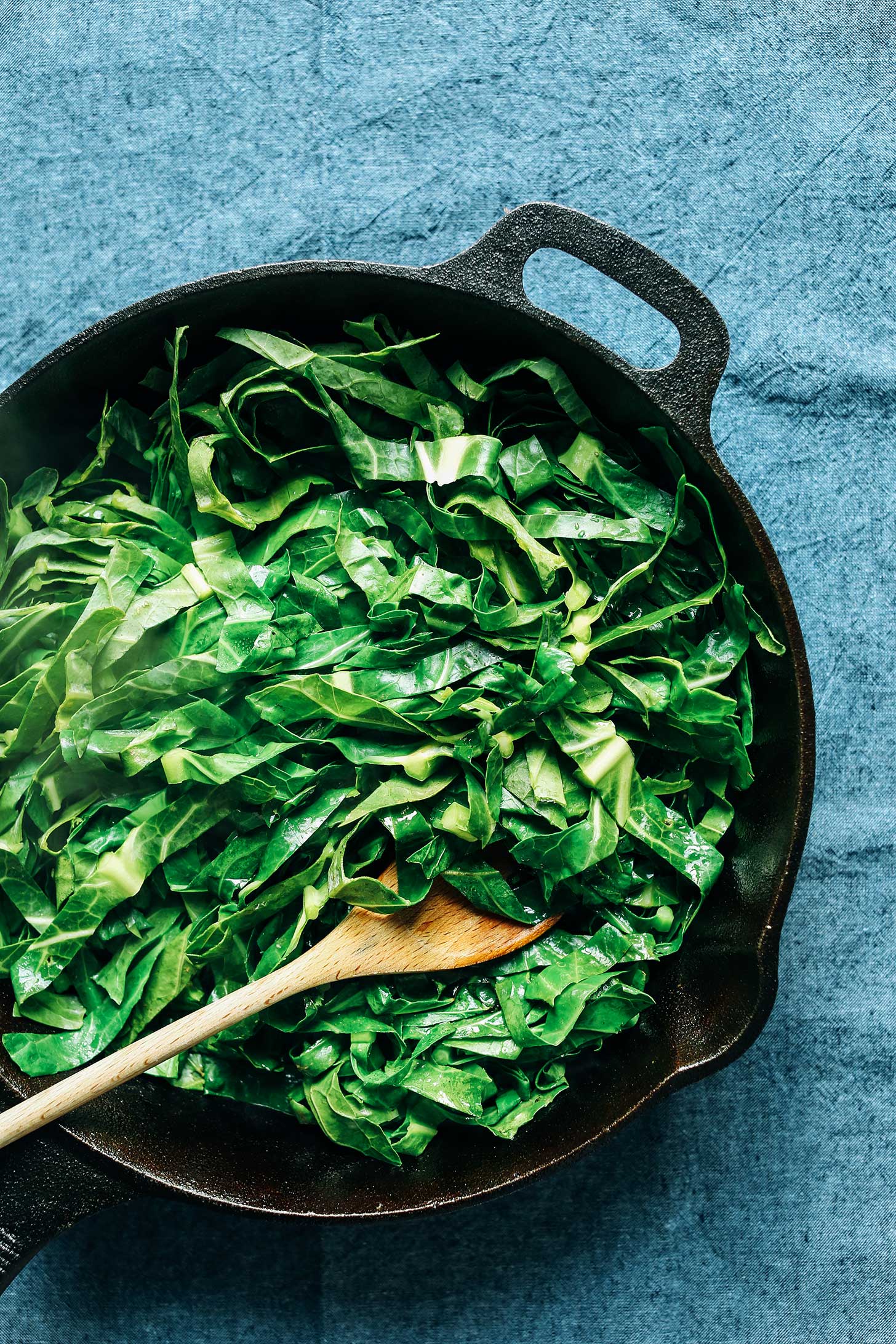 Cast iron skillet filled with a quick and easy vegan side dish of Collard Greens with Coconut Bacon