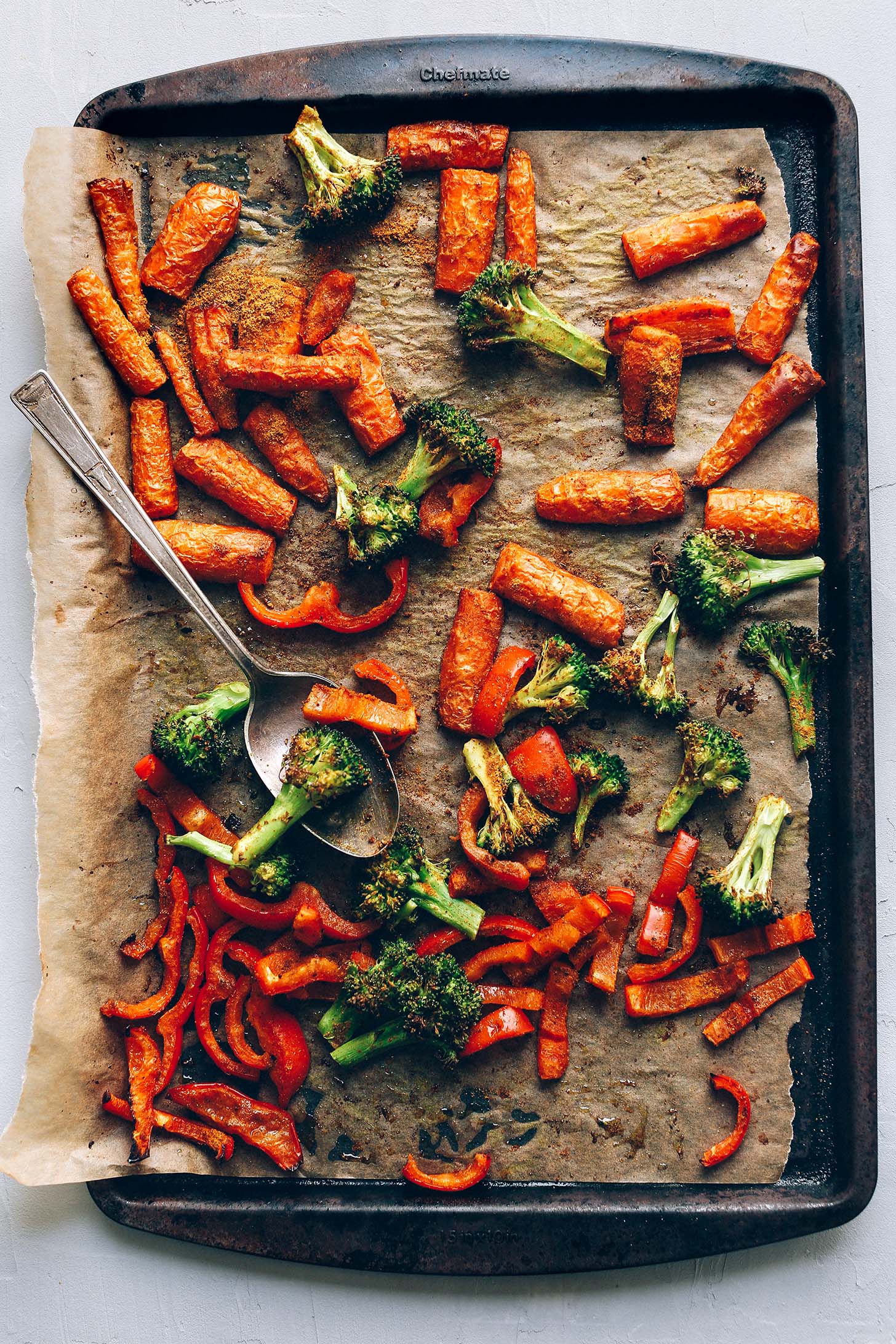 Parchment-lined baking sheet with roasted carrots and broccoli for a delicious Lentil Curry Salad recipe