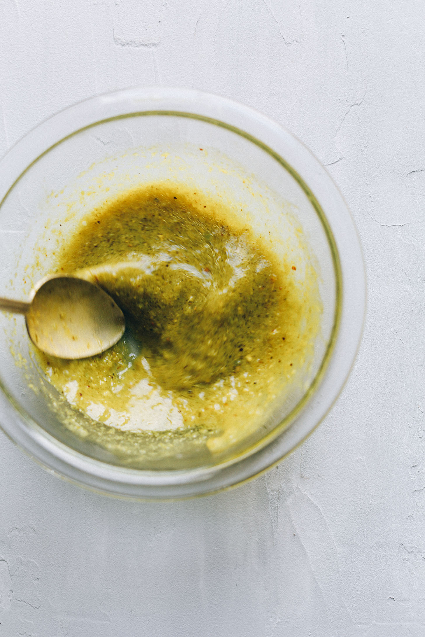 Stirring ingredients for green curry dressing to go over a delicious gluten-free vegan whole meal salad