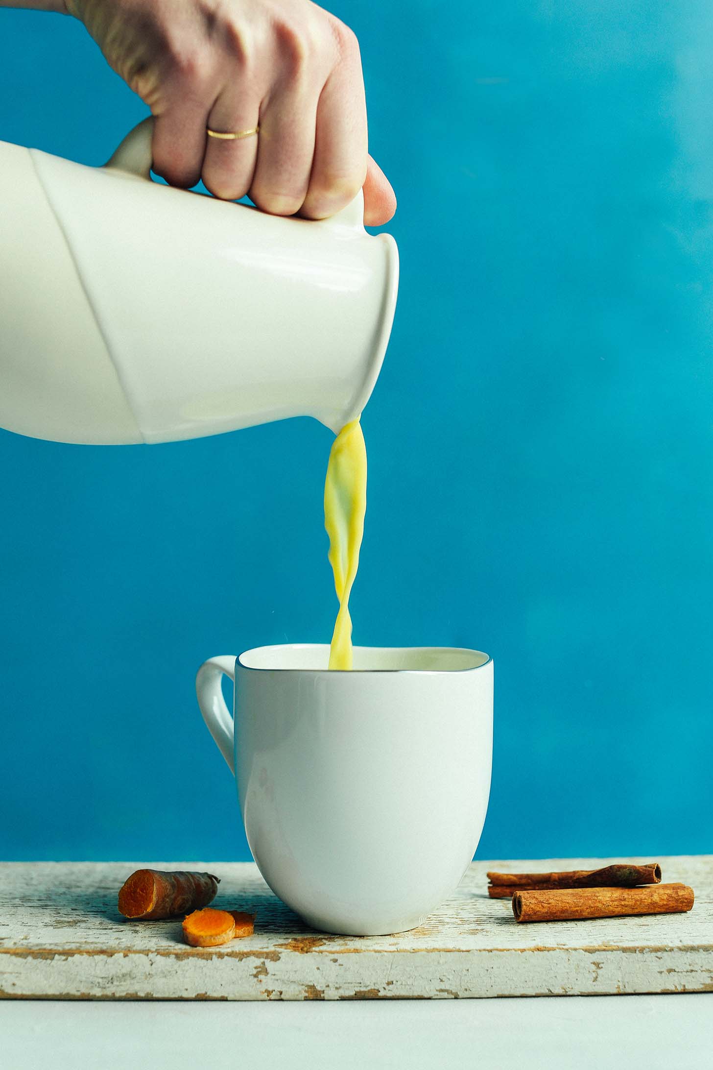 Pouring Creamy Golden Milk into a mug to be enjoyed as an anti-inflammatory boost