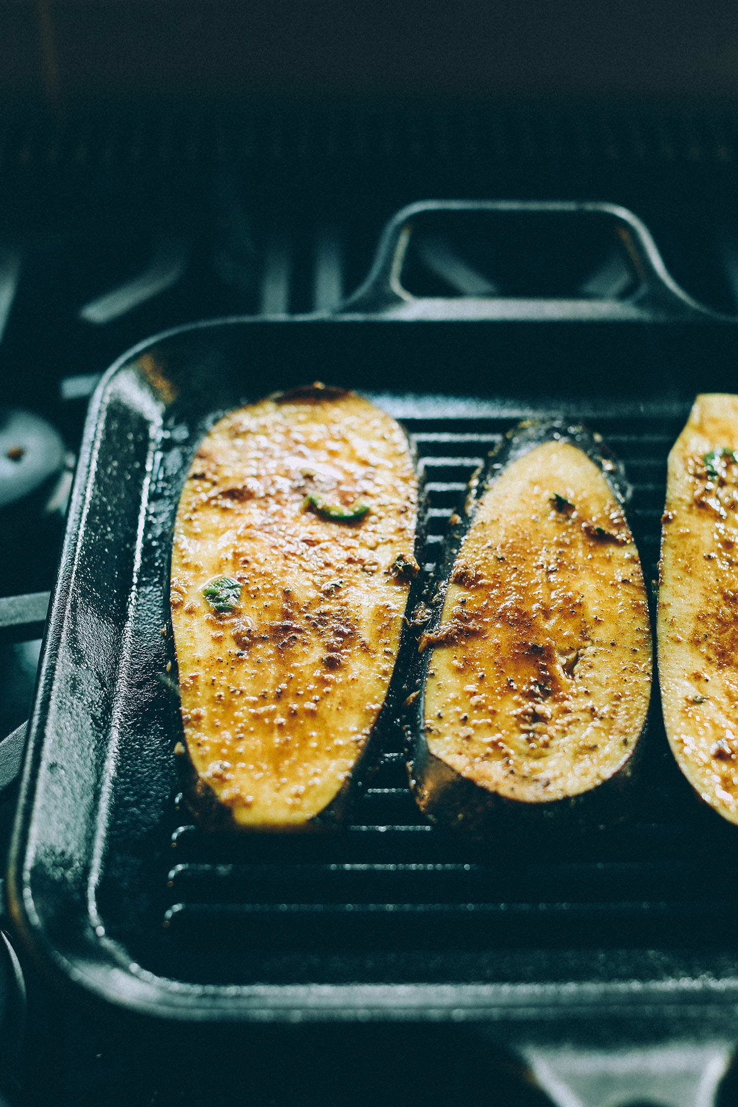 Cooking thinly sliced Jamaican Jerk Eggplant on a cast iron griddle pan