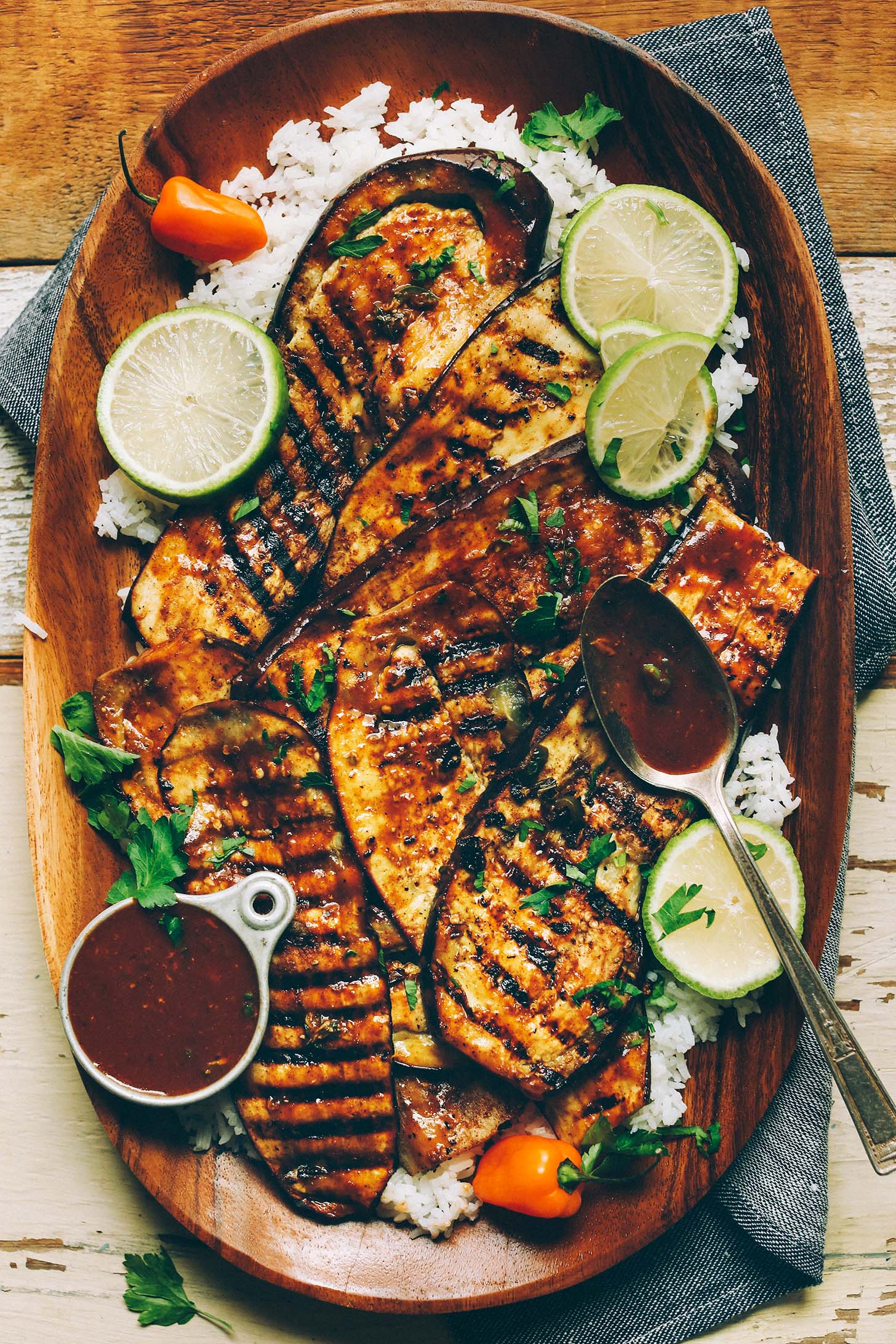 Wood platter with rice topped with vegan Grilled Jamaican Jerk Eggplant