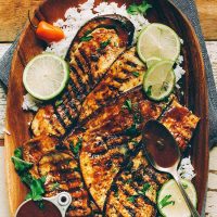 Wood platter filled with Vegan Jerk Eggplant slices over white rice