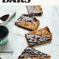 Homemade crunchy baked granola bars on a wood plank with text above that says vegan and gluten-free