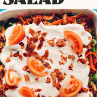 Overhead photo of a casserole dish filled with our vegan 7-layer salad with text above that says perfect for holiday parties