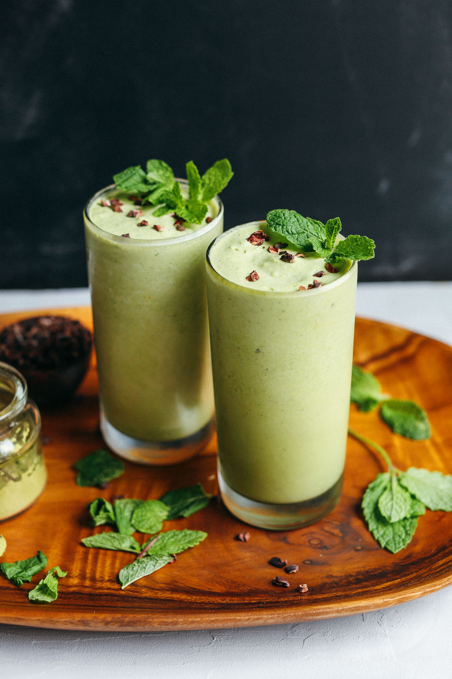 Wood platter with two Vegan Mint Shamrock Shakes