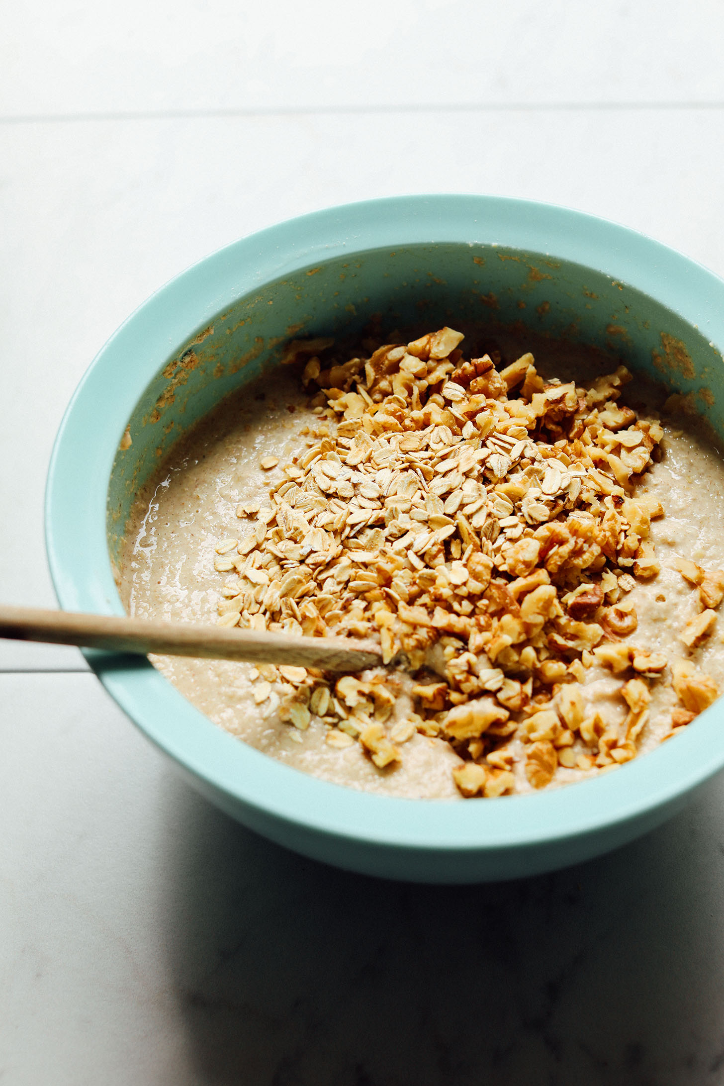 Stirring oats and walnuts into gluten-free Banana Pancakes batter