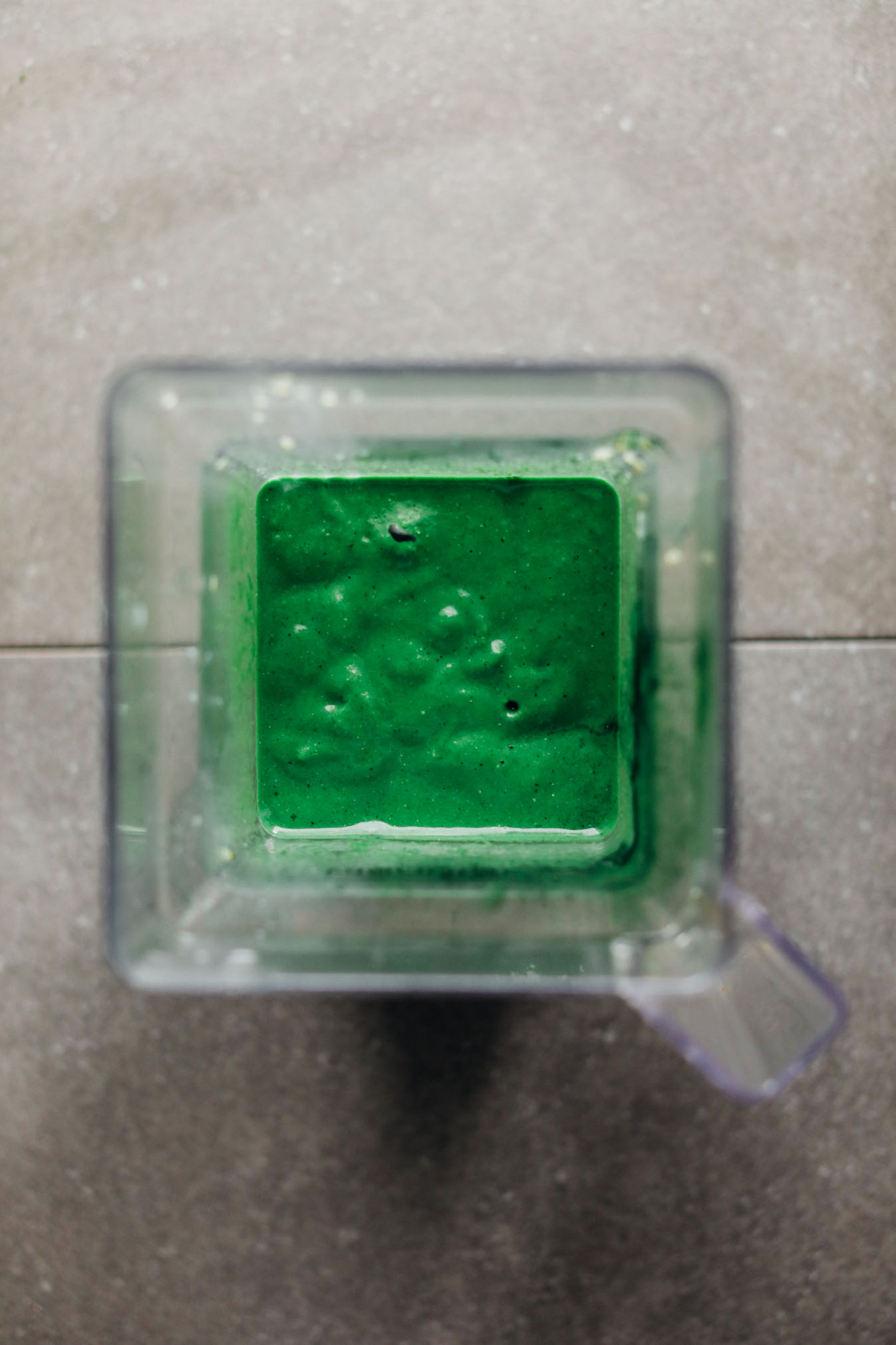 Blender with vibrant turquoise-colored vegan Super Green Smoothie with Spirulina