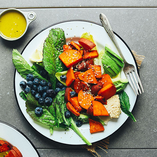 Plate of our Vegan Breakfast salad made with blueberries, sweet potato, avocado, and hummus