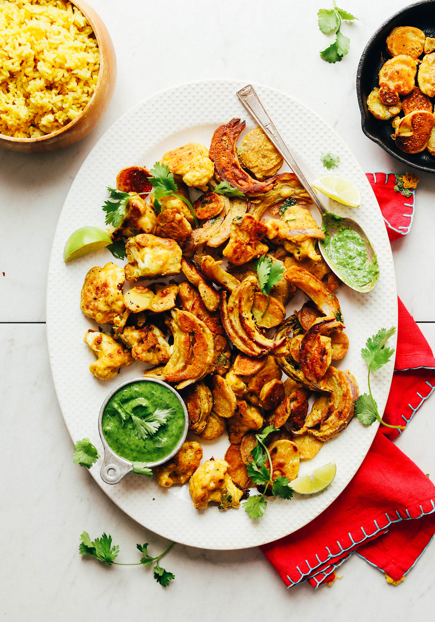 Ceramic serving platter filled with delicious gluten-free Vegetable Pakoras and green chutney
