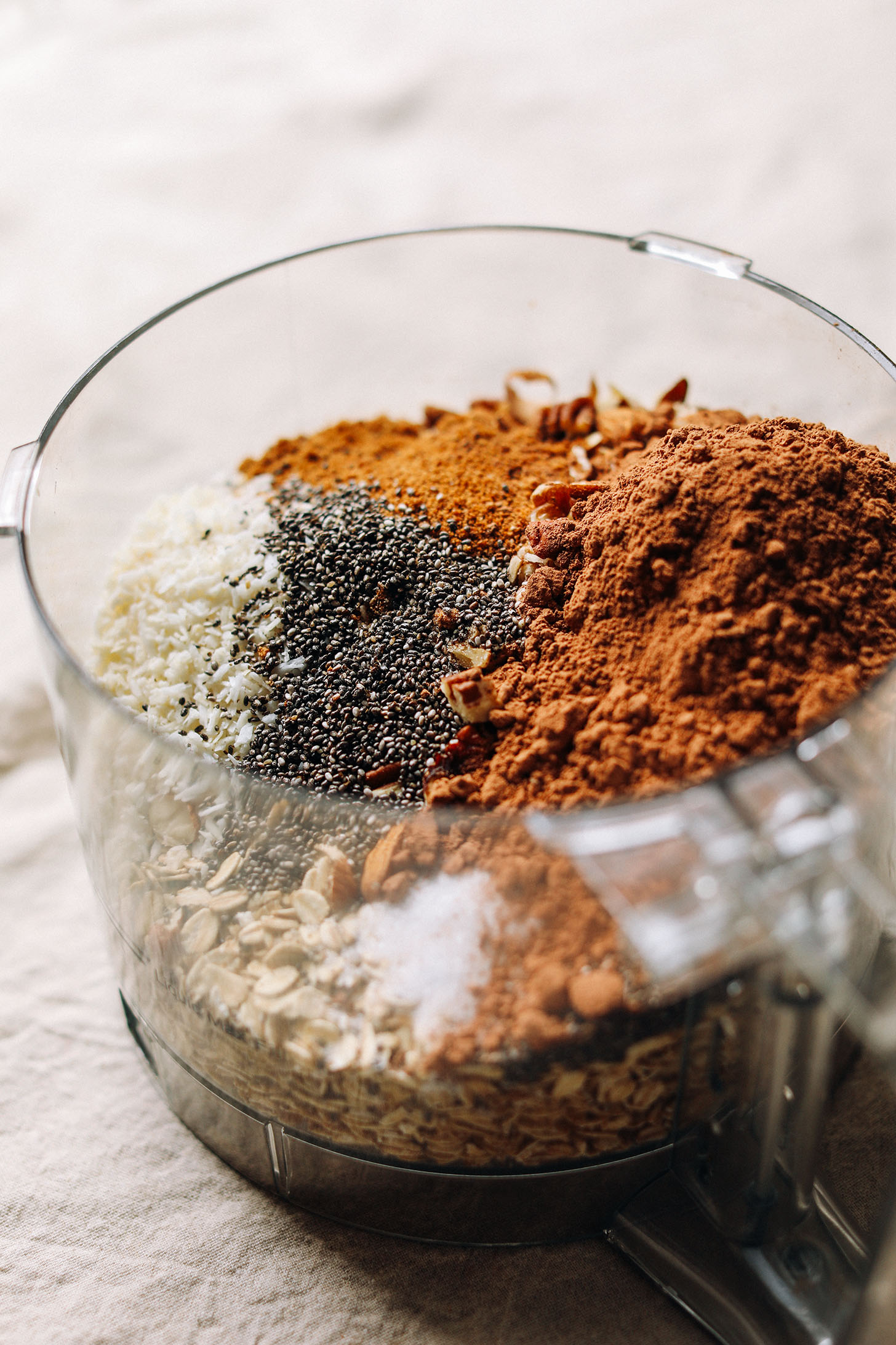 Food processor with ingredients for gluten-free vegan Dark Chocolate Granola