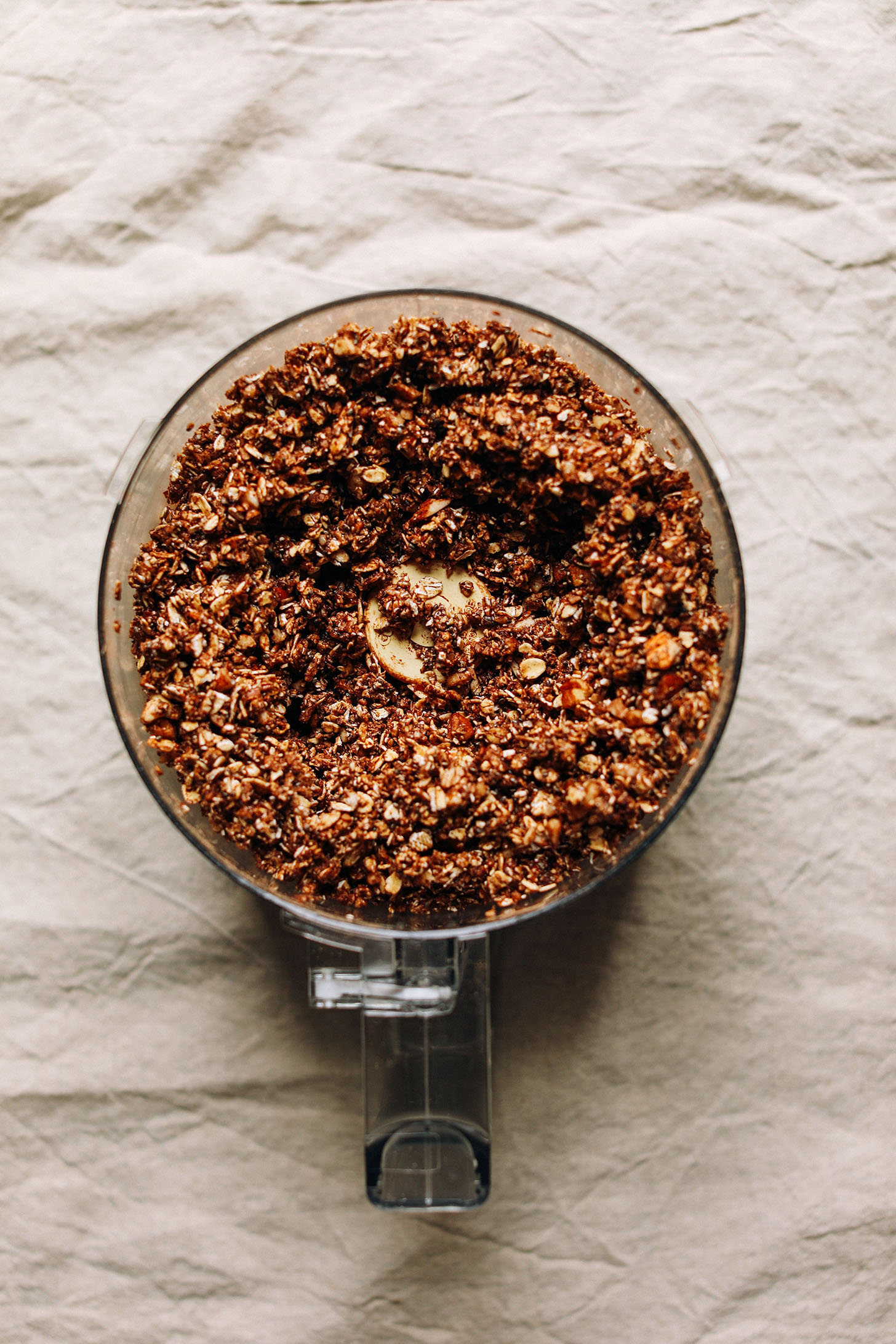 Food processor with freshly blended ingredients for Dark Chocolate Granola with sea salt