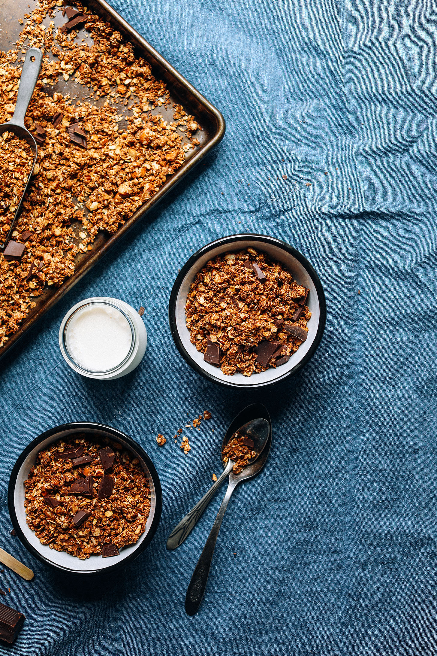 Baking sheet and two serving bowls with gluten-free vegan Dark Chocolate Granola with sea salt