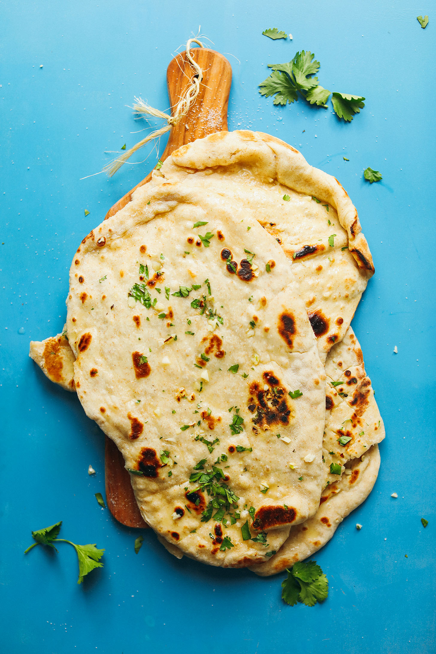 Wood cutting board stacked with Vegan Naan flatbreads