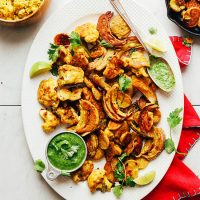 Platter of our delicious Vegetable Pakoras alongside a measuring cup filled with chutney