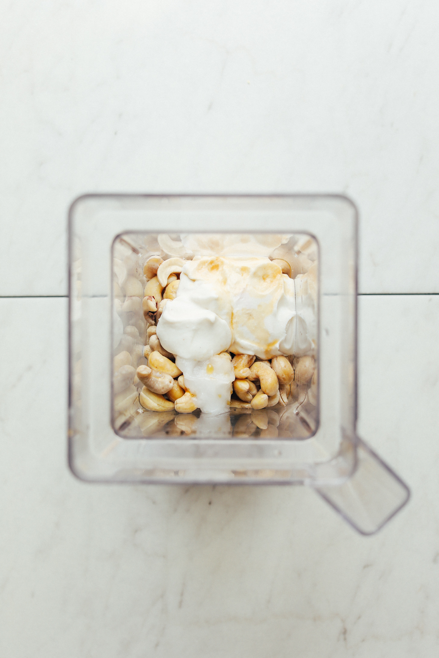 Blender with ingredients for making vegan Cashew Buttercream Frosting