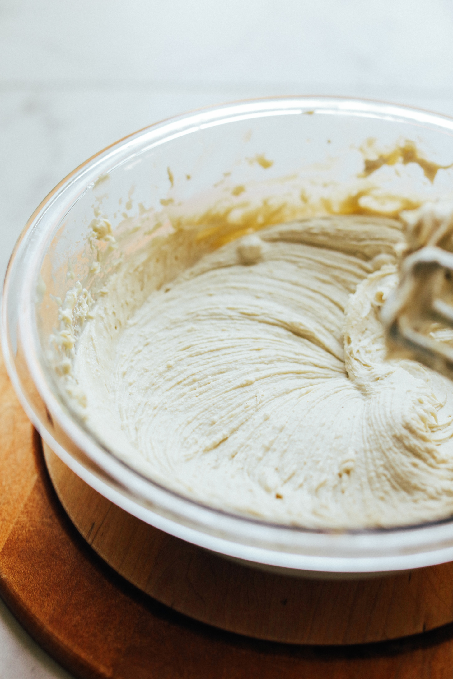 Whipping Creamy Cashew Buttercream Frosting in a mixing bowl