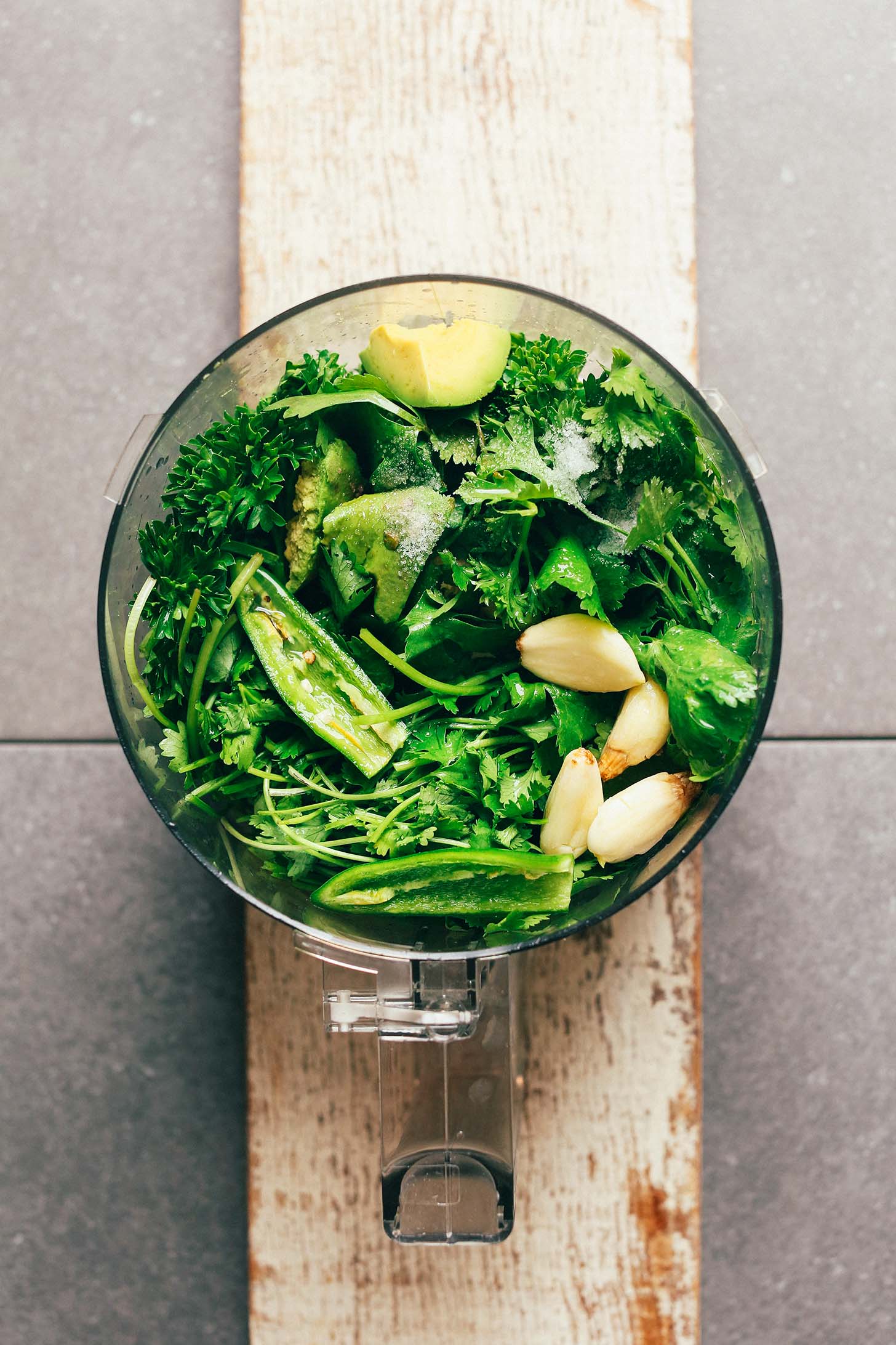 Food processor filled with ingredients for making homemade Chimichurri