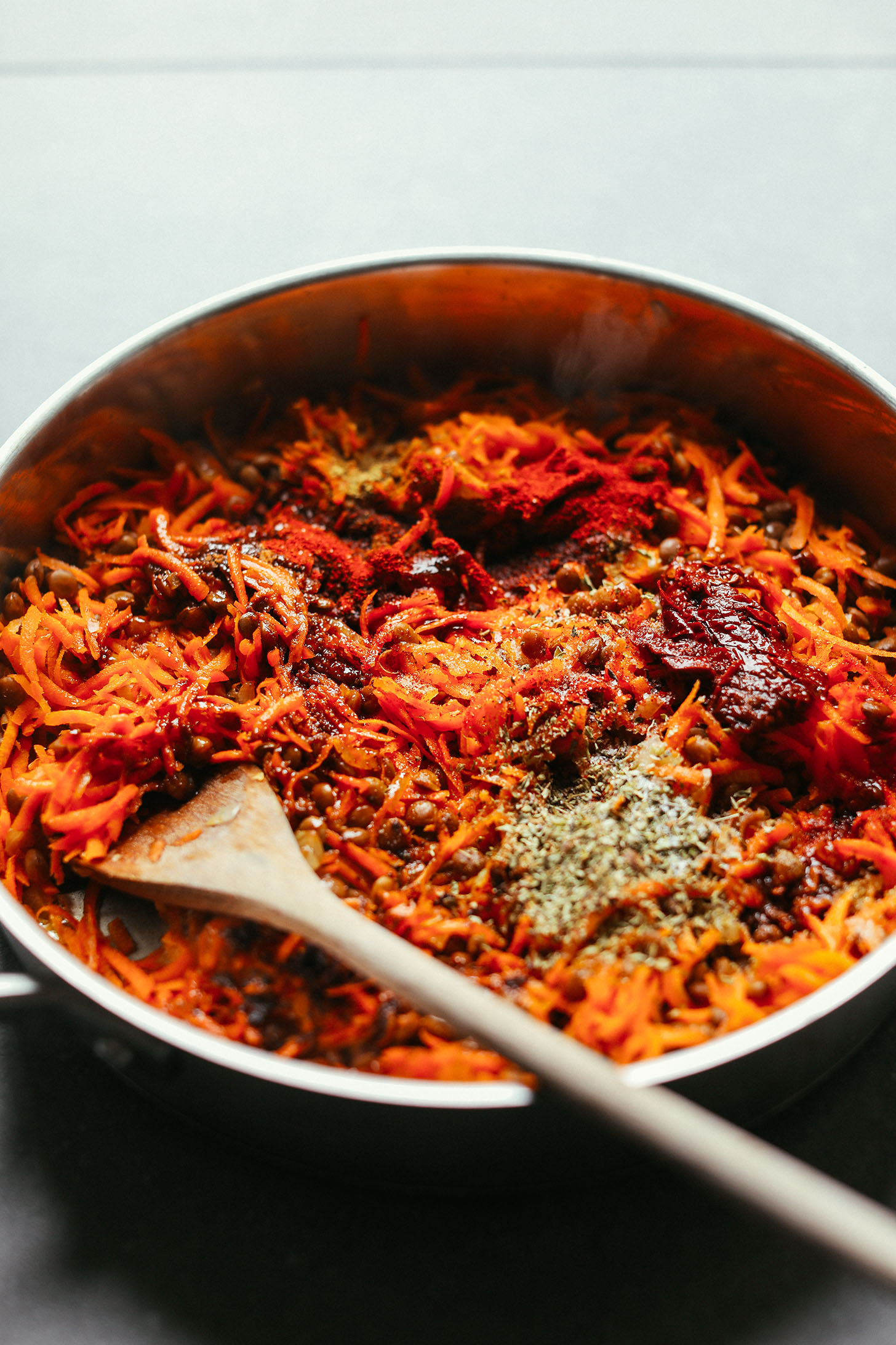Stirring together ingredients for healthy Vegan Barbacoa made with lentils and carrots