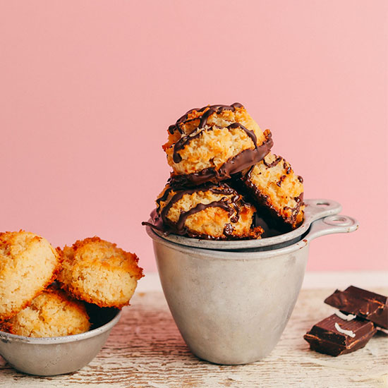 Measuring cups of Easy Vegan Macaroons with some dipped in chocolate and others plain
