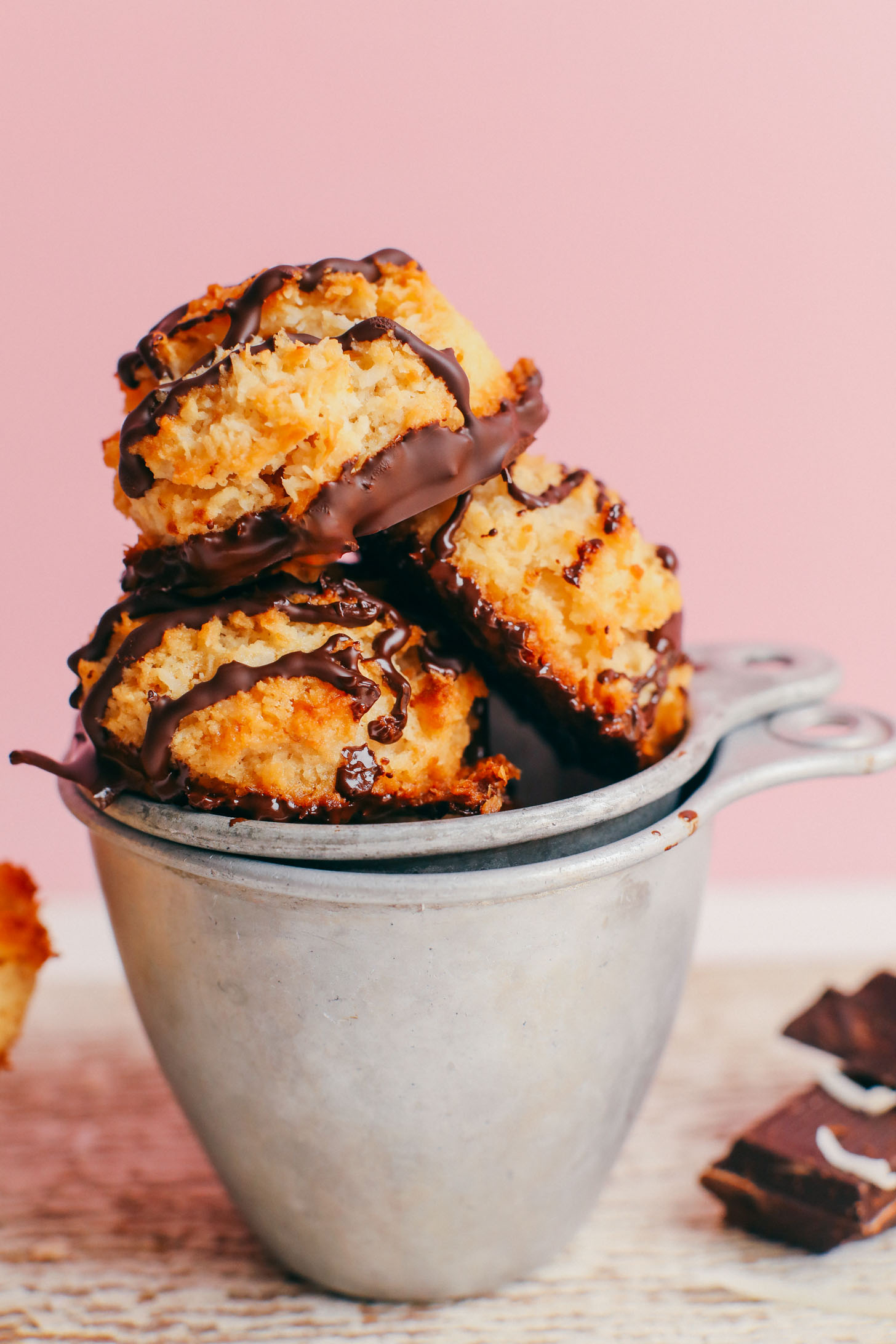 Three stacked Crispy Vegan Macaroons balanced on vintage measuring cups