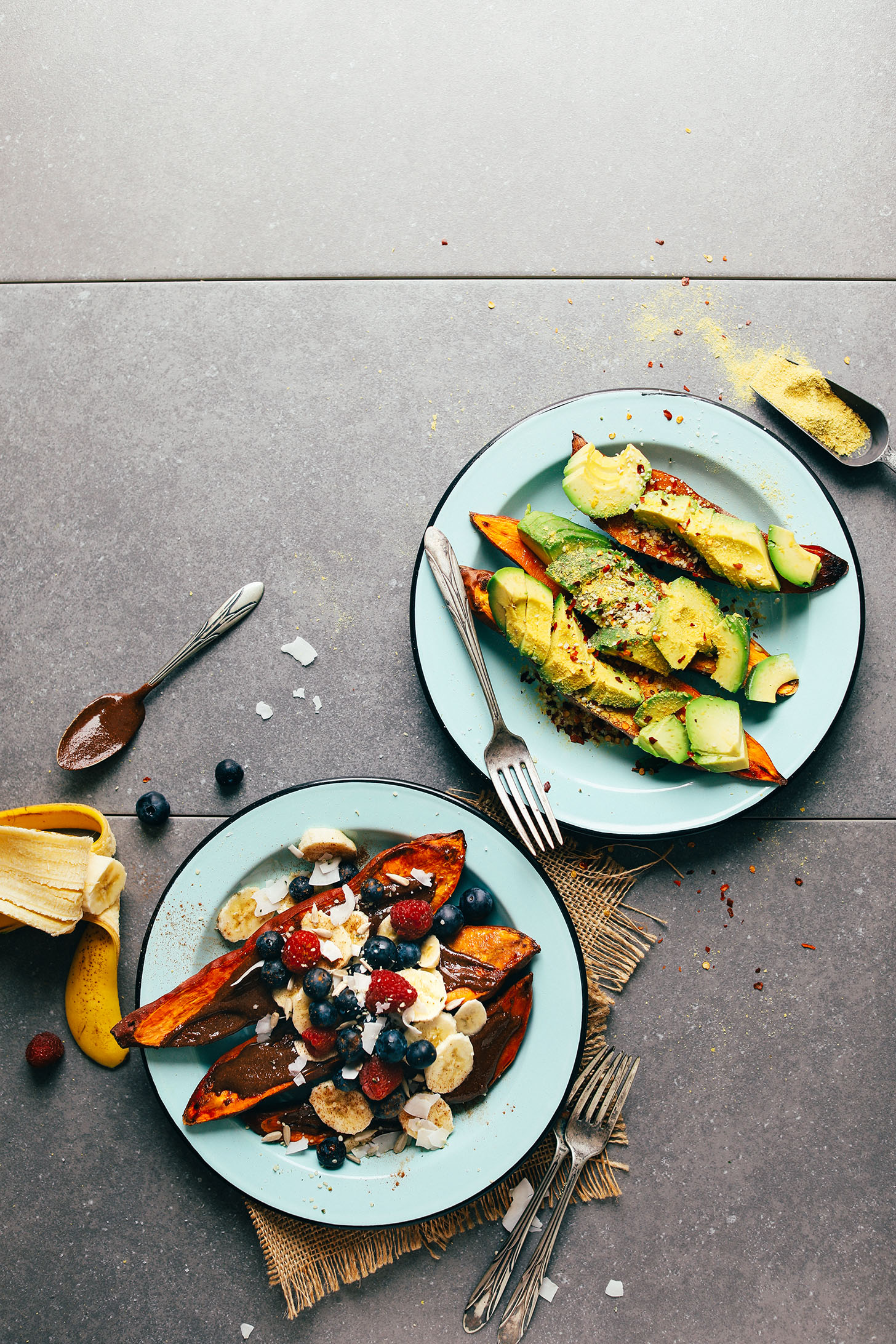A savory plate of baked sweet potato with avocado, chili flakes, nutritional yeast, and salt and a sweet plate of baked sweet potato with fresh fruit, chocolate, and coconut