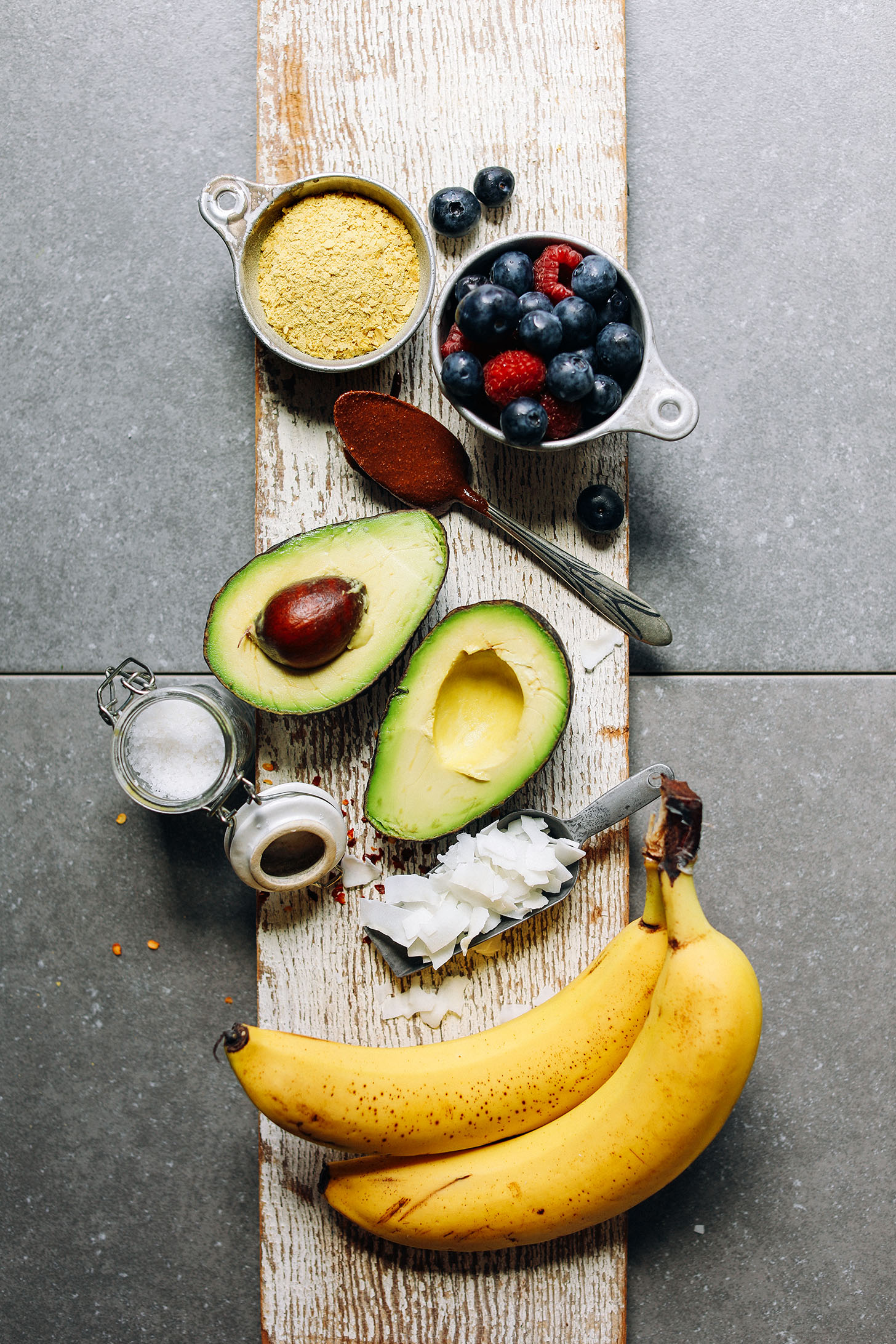 Wood plank showcasing toppings for savory and sweet baked potatoes
