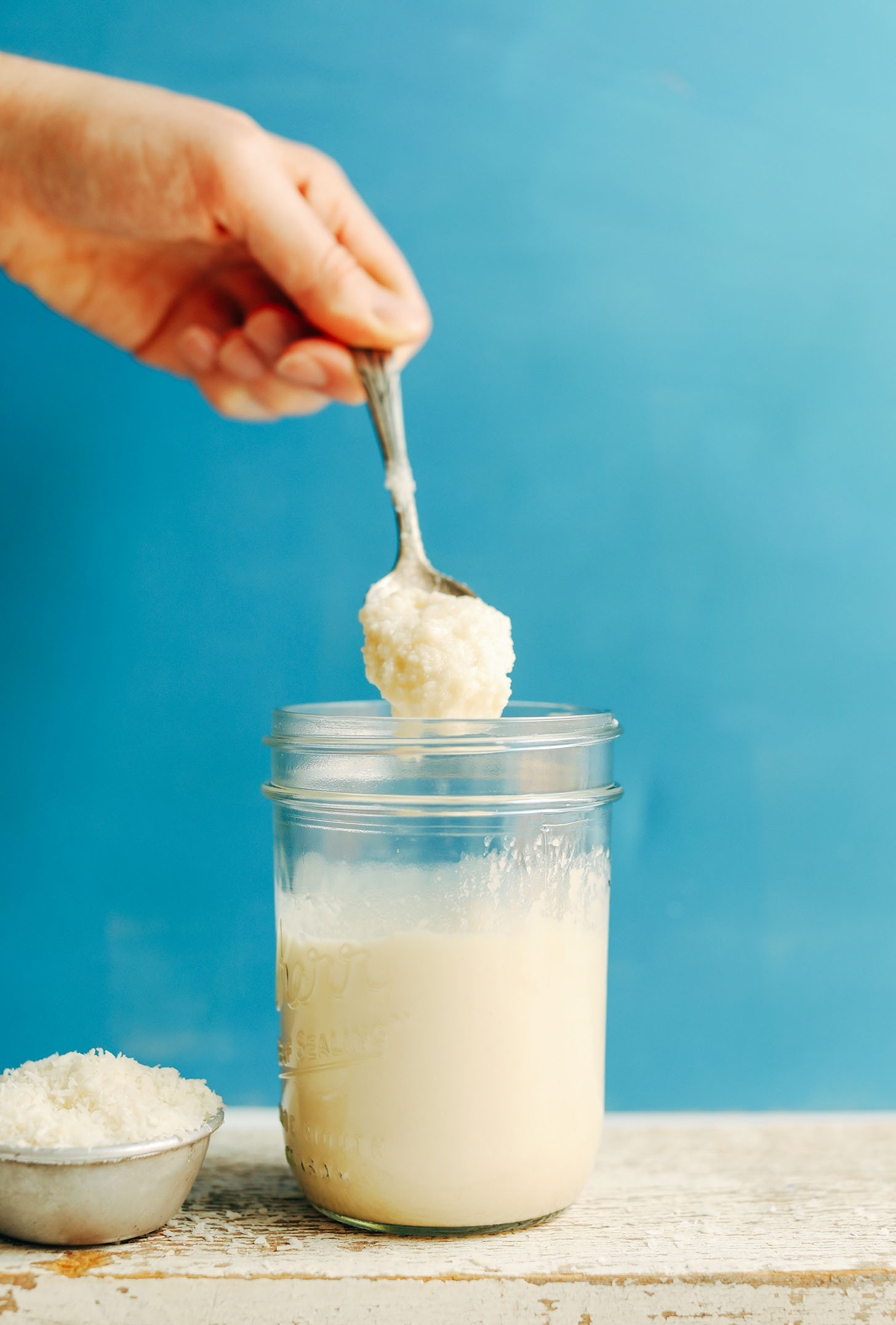 Using a spoon to grab a scoop of homemade coconut butter