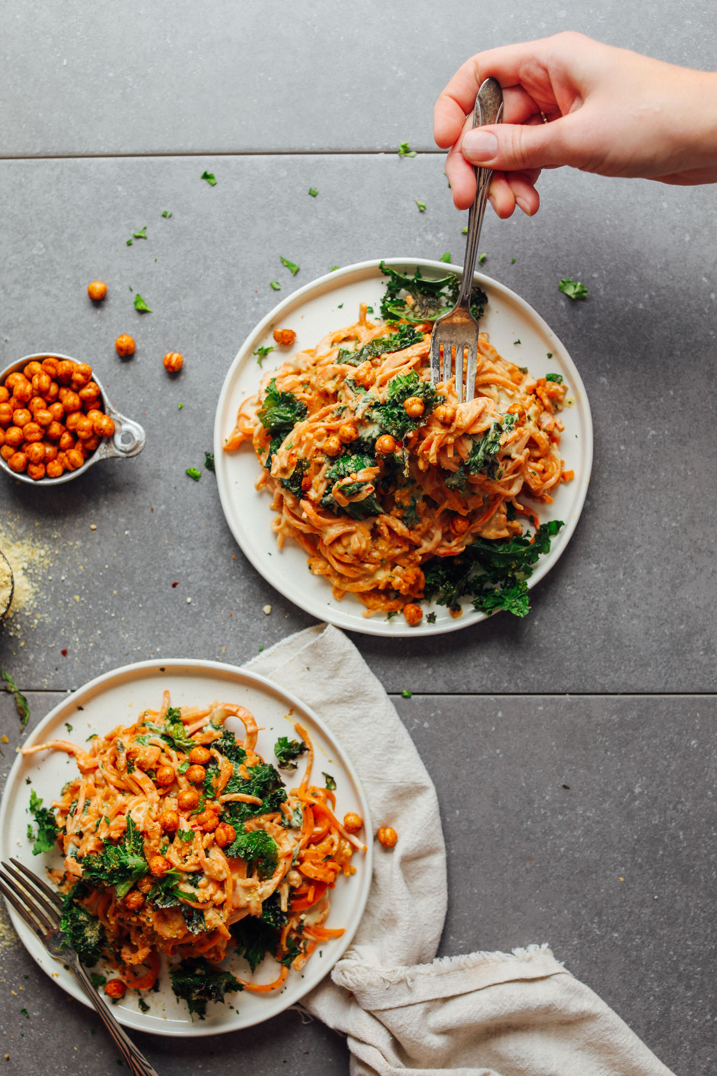 Two dinner plates with large servings of Garlicky Sweet Potato Pasta with Crispy Kale