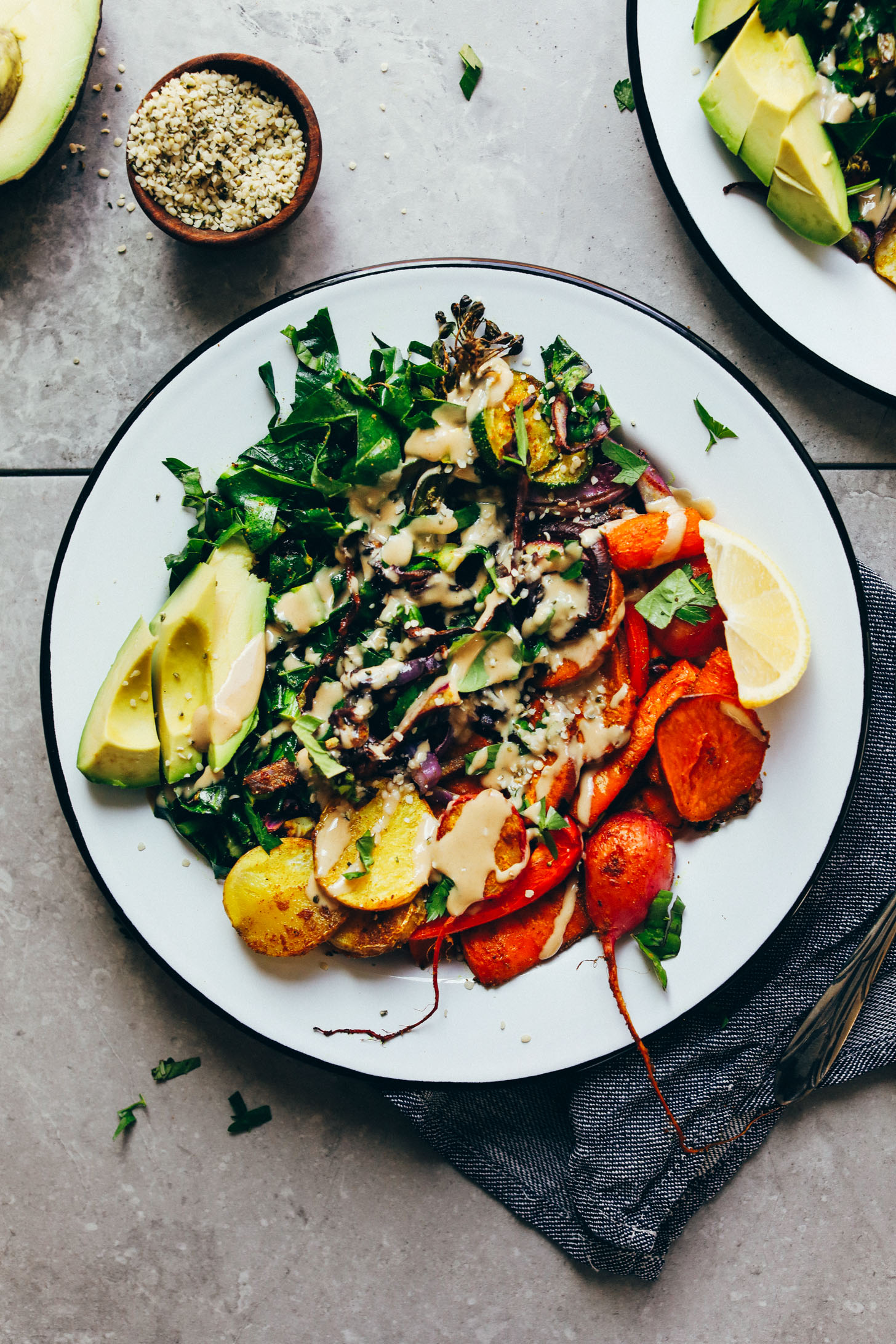 Close up shot of the many colors of vegetables in our Roasted Rainbow Vegetable Bowl with hemp seeds and tahini dressing