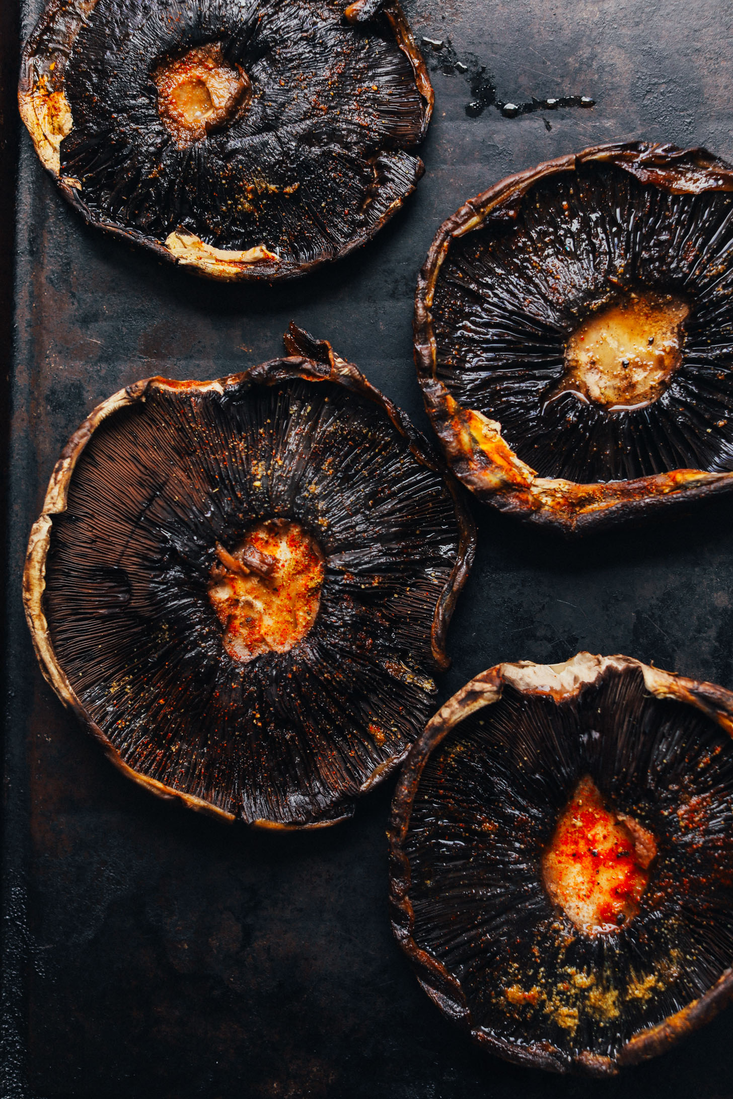 Baking sheet with portobello mushrooms marinated in avocado oil, balsamic vinegar, and spices