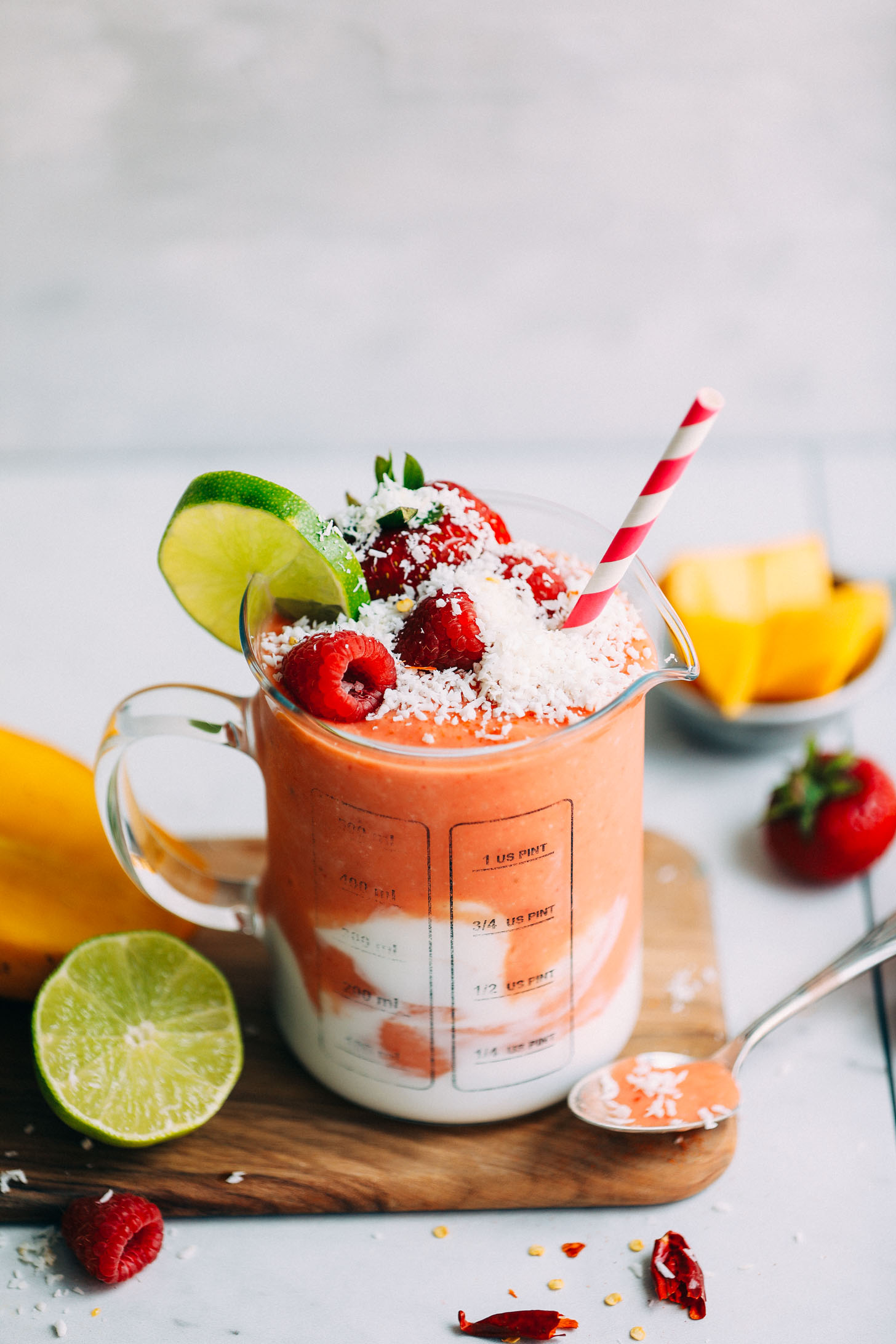 Glass serving jar filled with banana-free Gingery Mango & Berry Smoothie