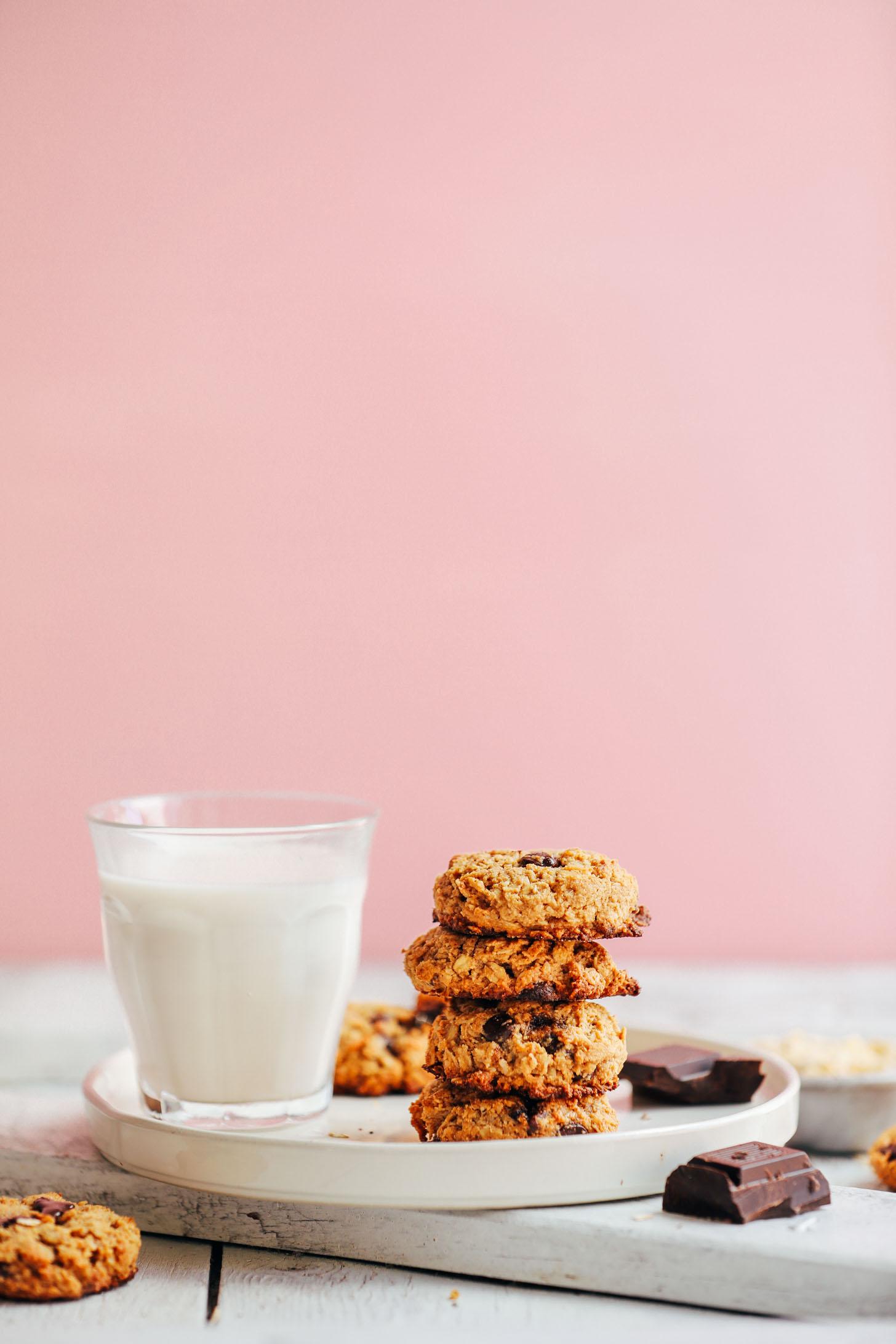 A stack of healthy Gluten-Free Oatmeal Chocolate Chip Cookies alongside a glass of dairy-free milk