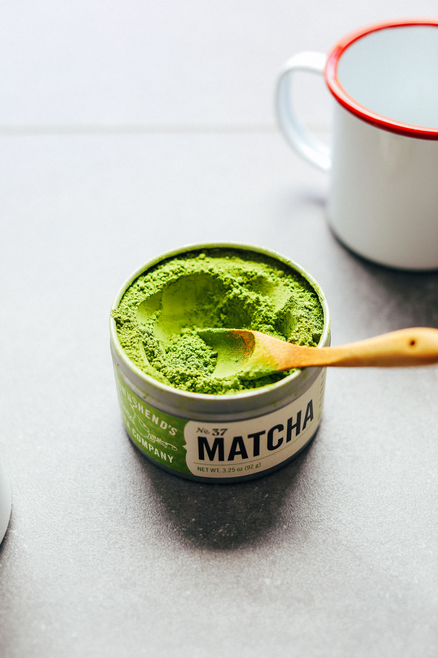 Using a small wooden spoon to grab a scoop of matcha powder for making the Best Matcha Latte
