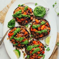 Platter of Vegetable Quinoa Stuffed Portobello Mushrooms with a measuring cup of chimichurri