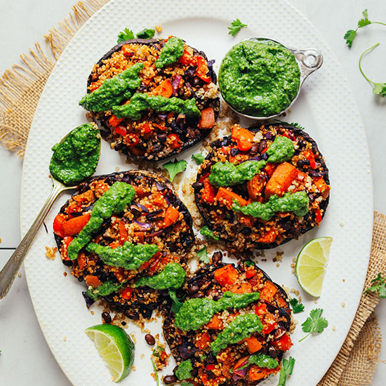 Platter of Vegetable Quinoa Stuffed Portobello Mushrooms with a measuring cup of chimichurri