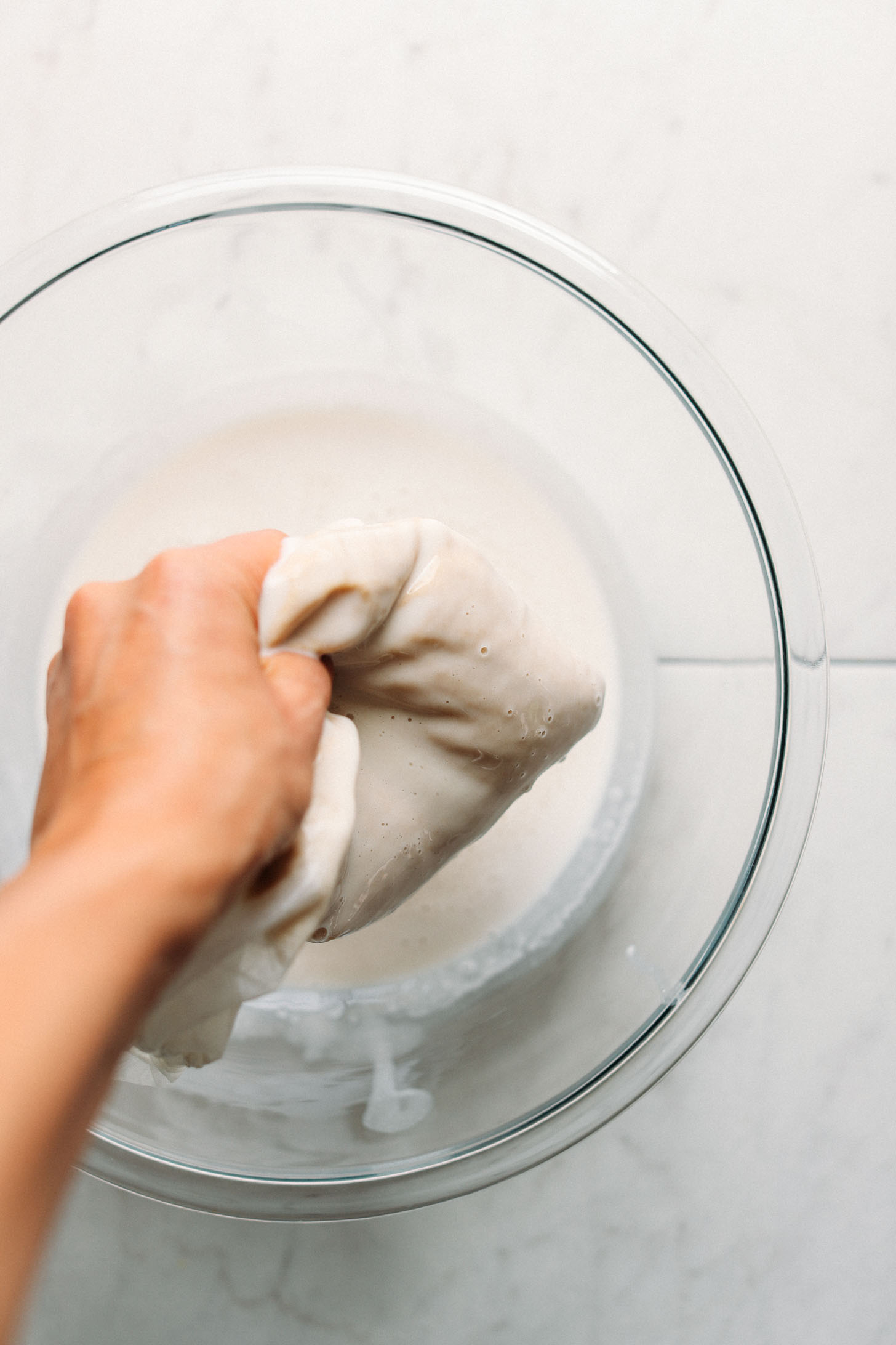 Squeezing DIY Macadamia Milk through a nut milk bag