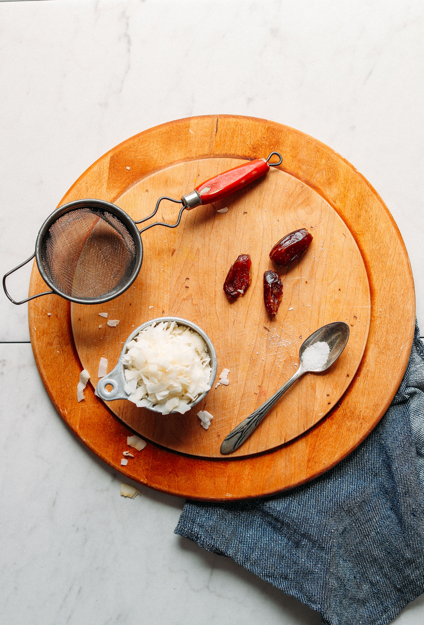 Wood cutting board with dates, salt, and coconut flakes