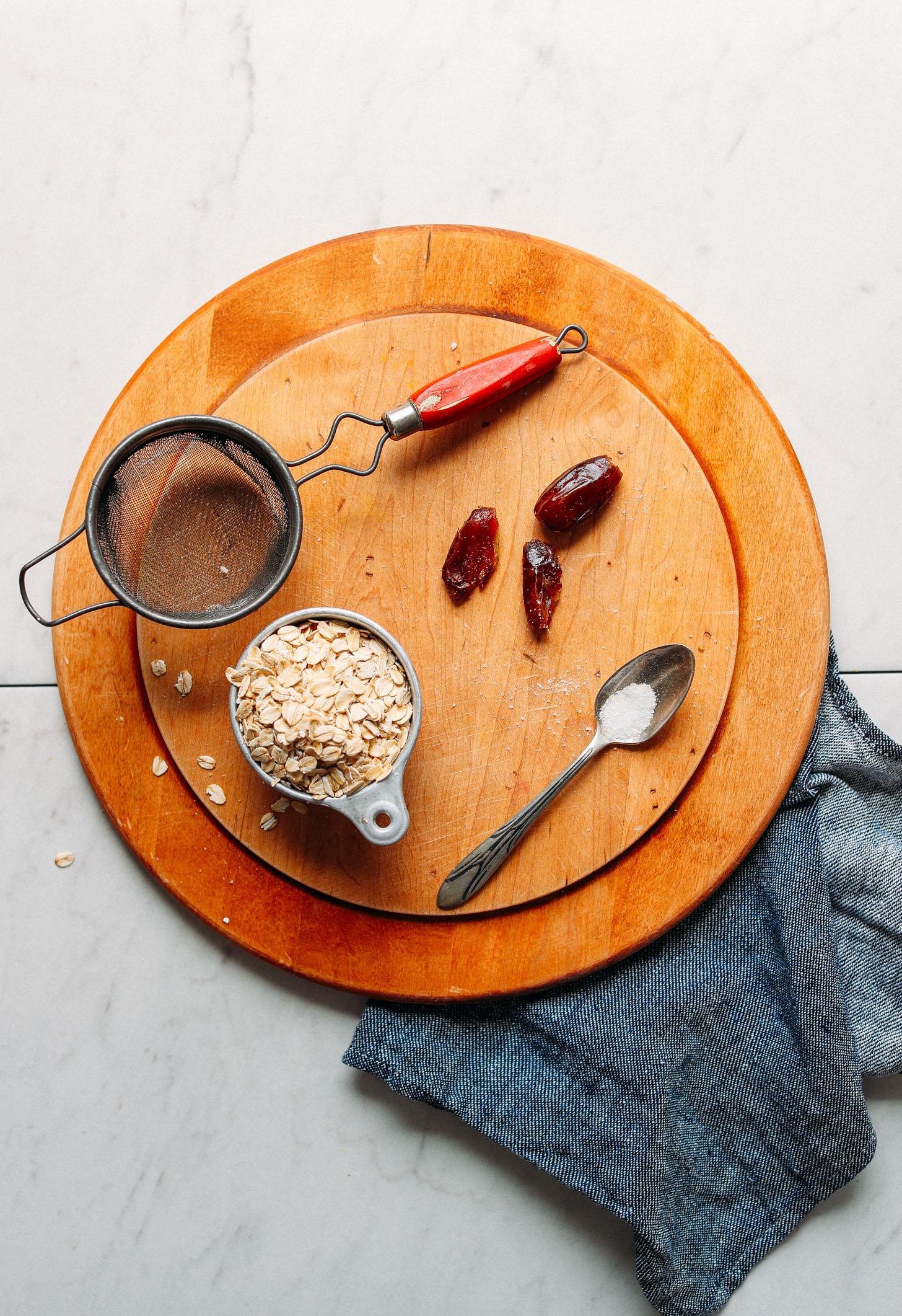 Wood cutting board with ingredients for making homemade Oat Milk
