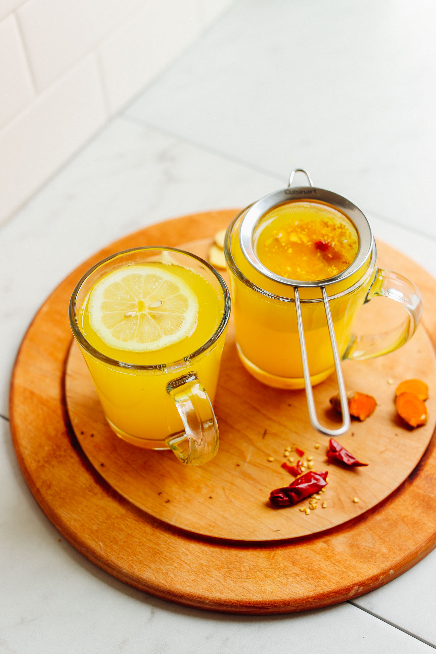 Two mugs filled with 3-Ingredient Turmeric Ginger Tonic