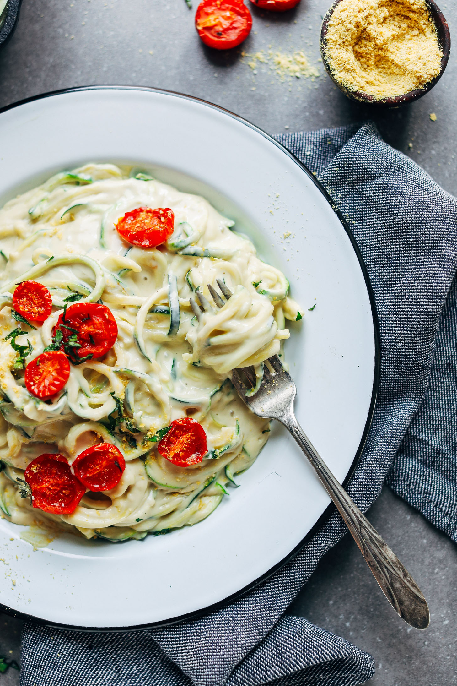 Swirling a fork into a big plate of 30-Minute Vegan Alfredo for a gluten-free plant-based dinner