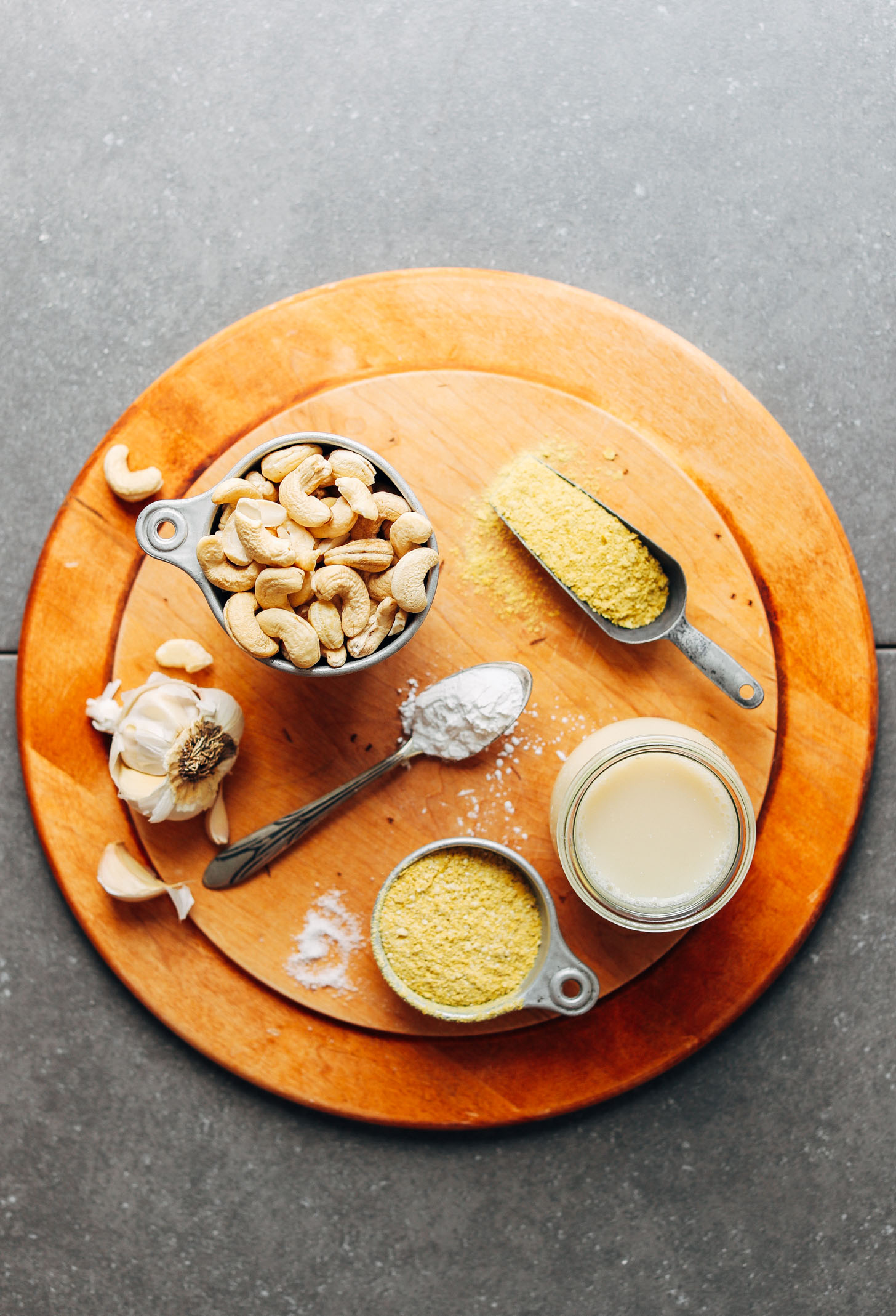 Wood platter filled with ingredients for making gluten-free vegan alfredo sauce