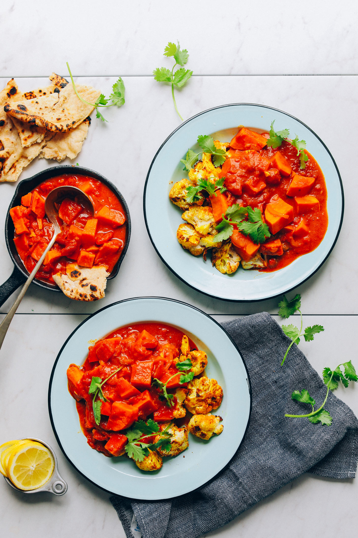 Serving bowls filled with Sweet Potato Aloo Gobi for a plant-based dinner