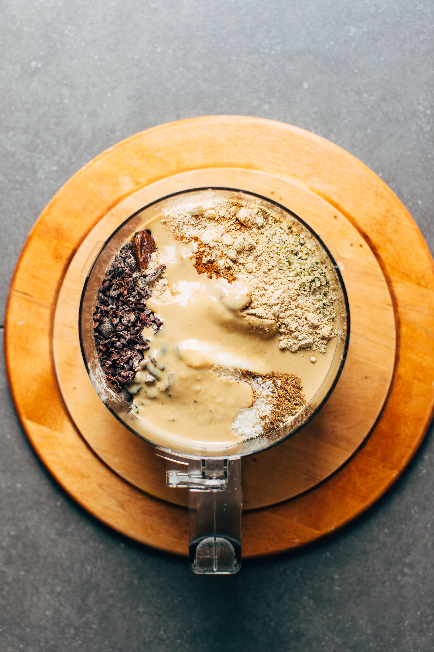 Food processor with ingredients for making protein-rich vegan Coconut Cacao Tahini Snack Bites