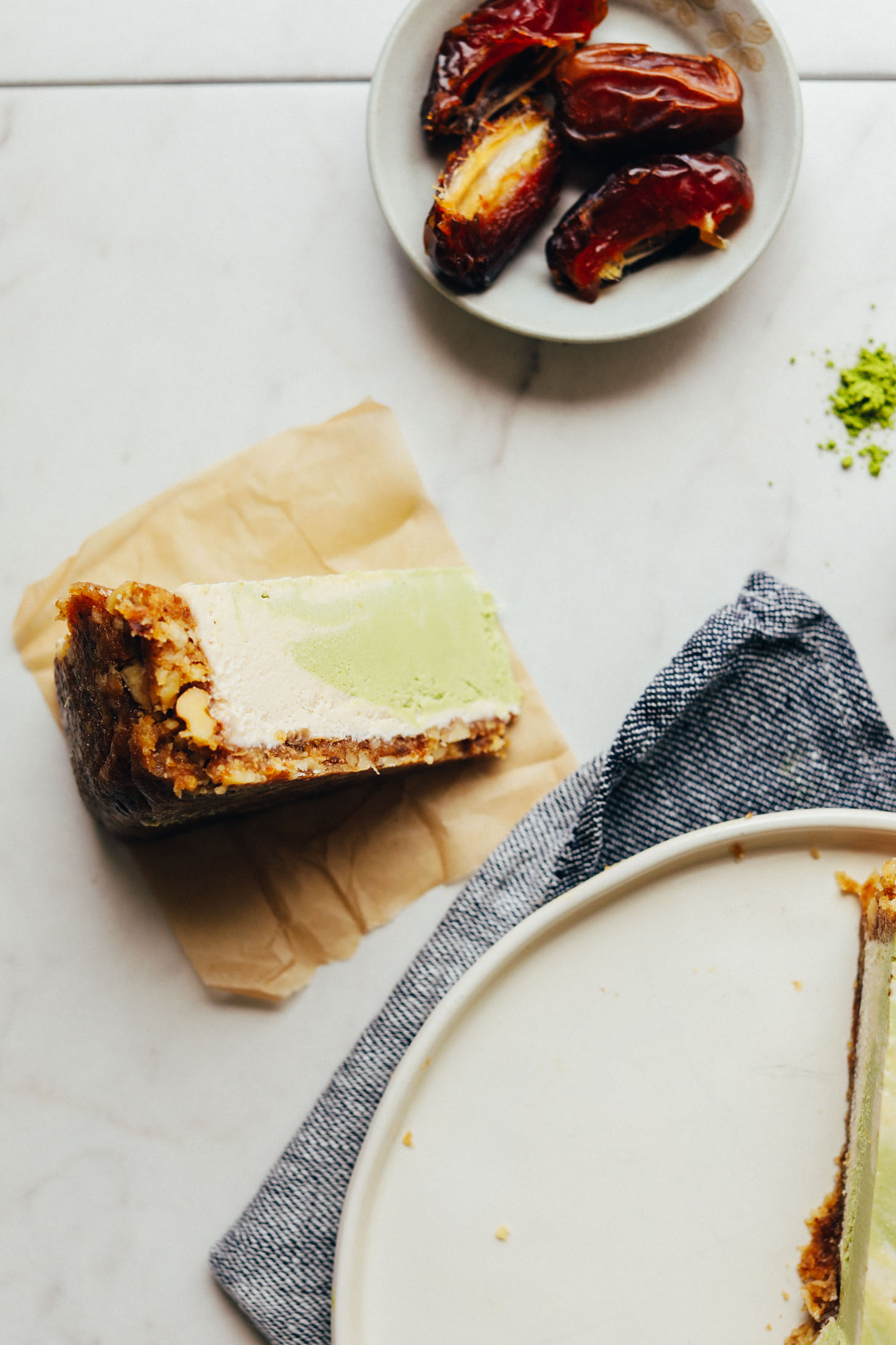 Slice of Matcha Swirl Cheesecake on a parchment paper square ready to be devoured for a delicious plant-based dessert