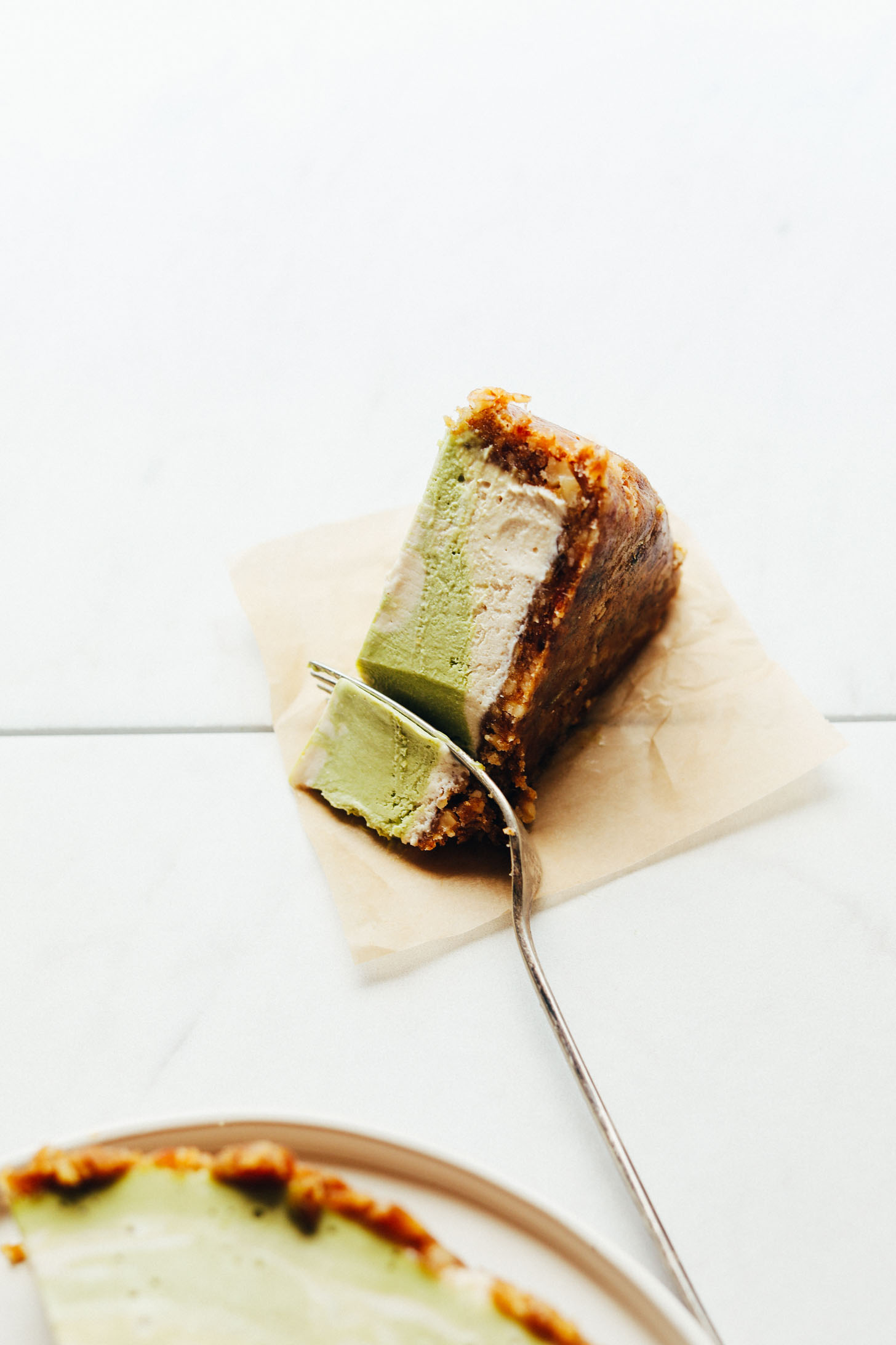 Cutting into a slice of this gorgeous two-tone Matcha Swirl Cheesecake