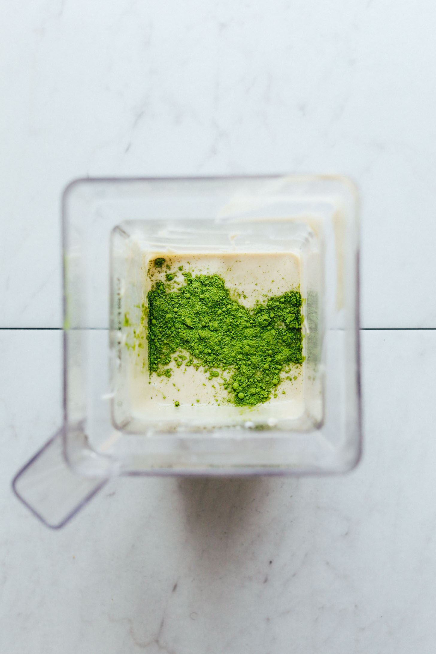 Matcha and other ingredients in a blender for making Matcha Swirl Cheesecake