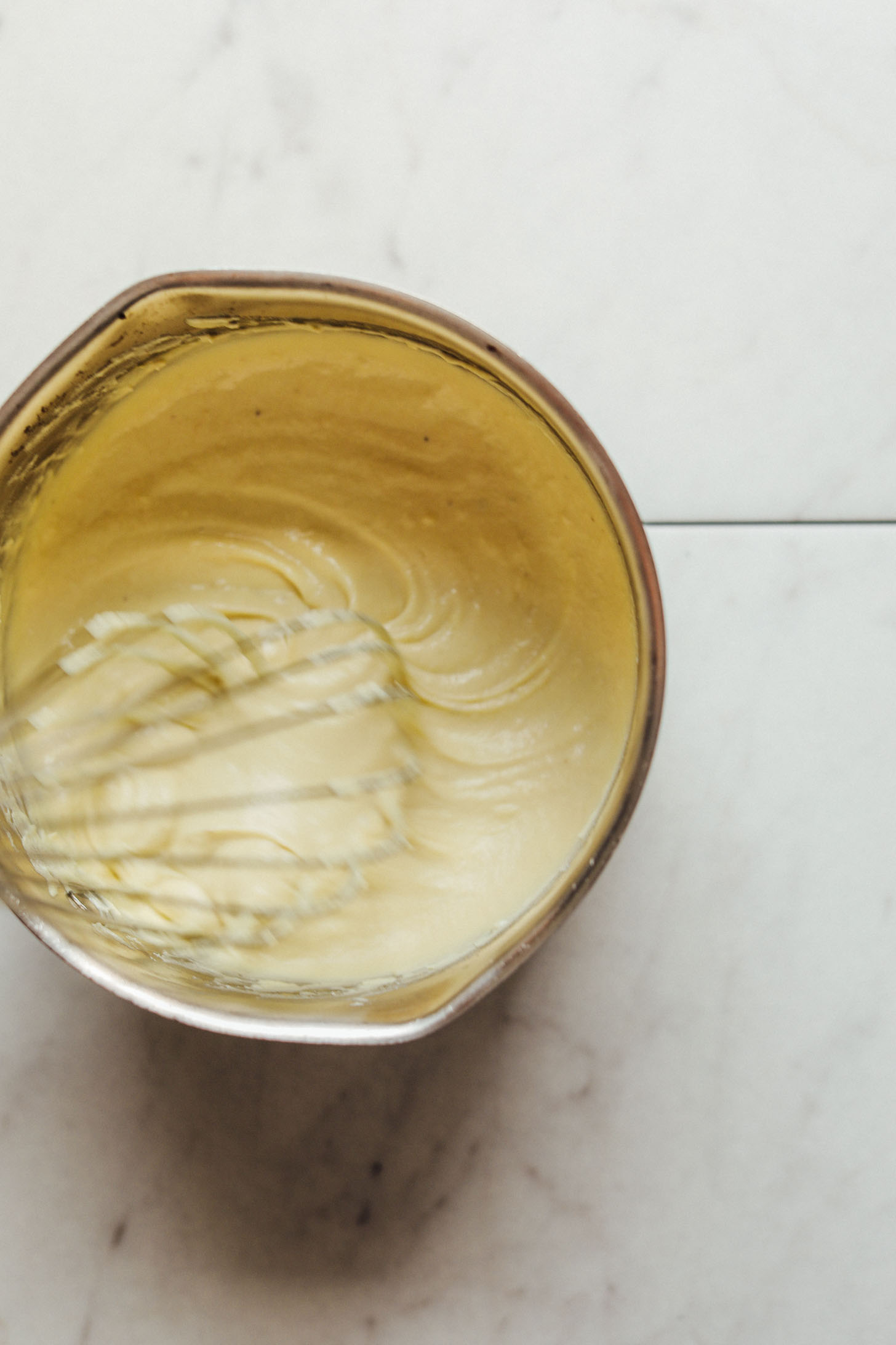 Whisking homemade Vegan Mozzarella Cheese in a saucepan