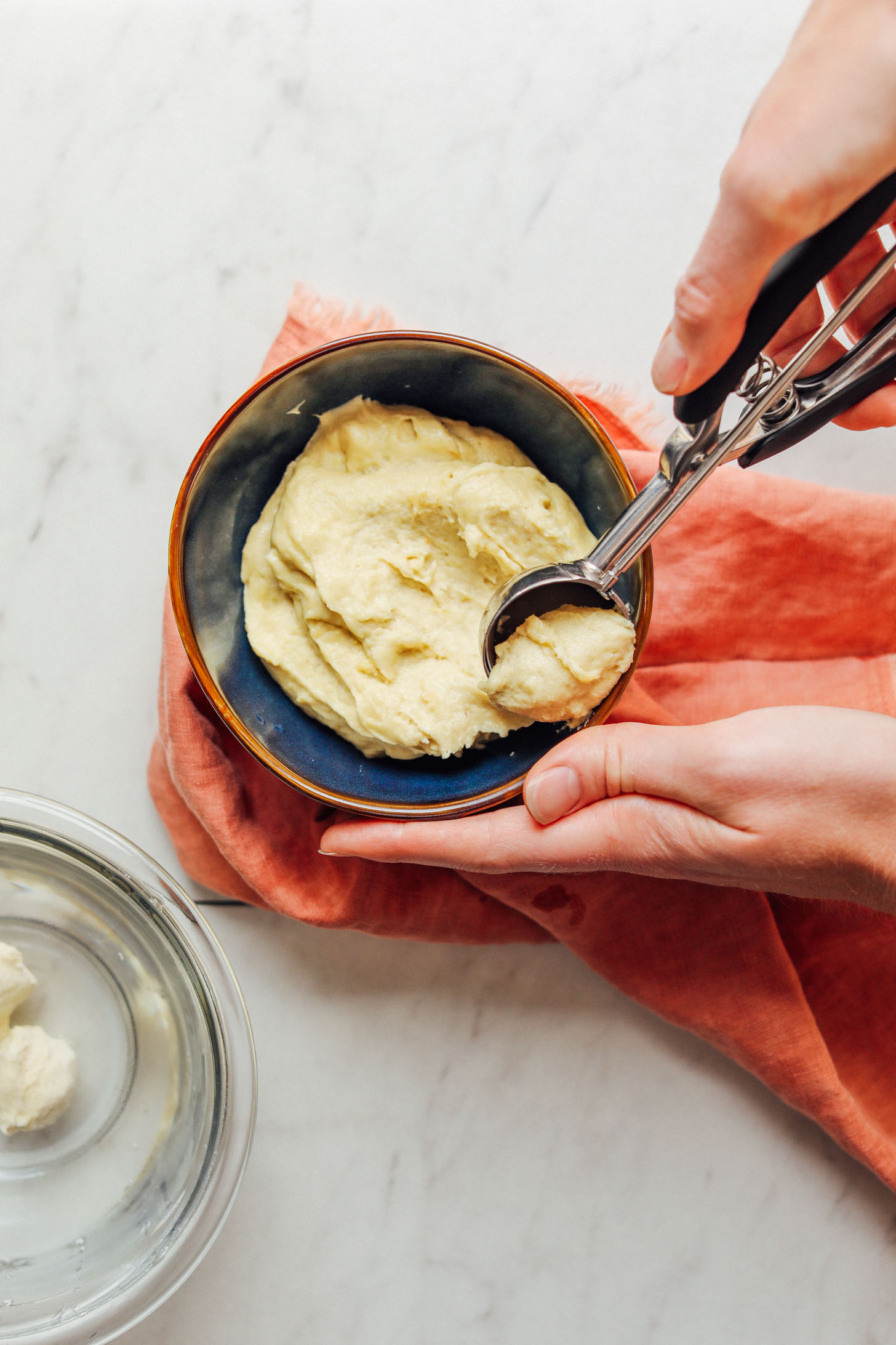 Using an ice cream scooper to grab some of our Vegan Mozzarella Cheese recipe