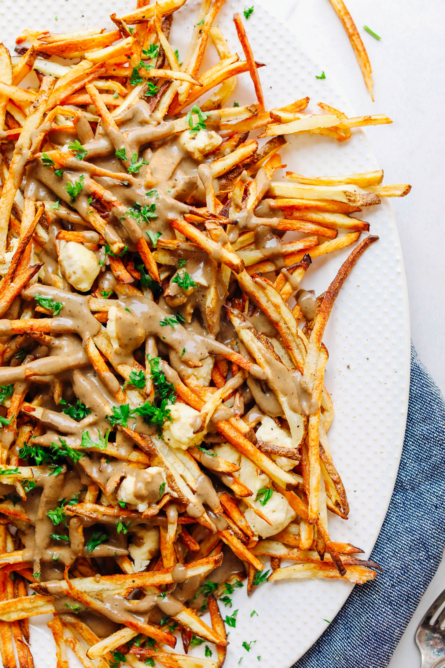Large ceramic platter filled with Vegan Poutine